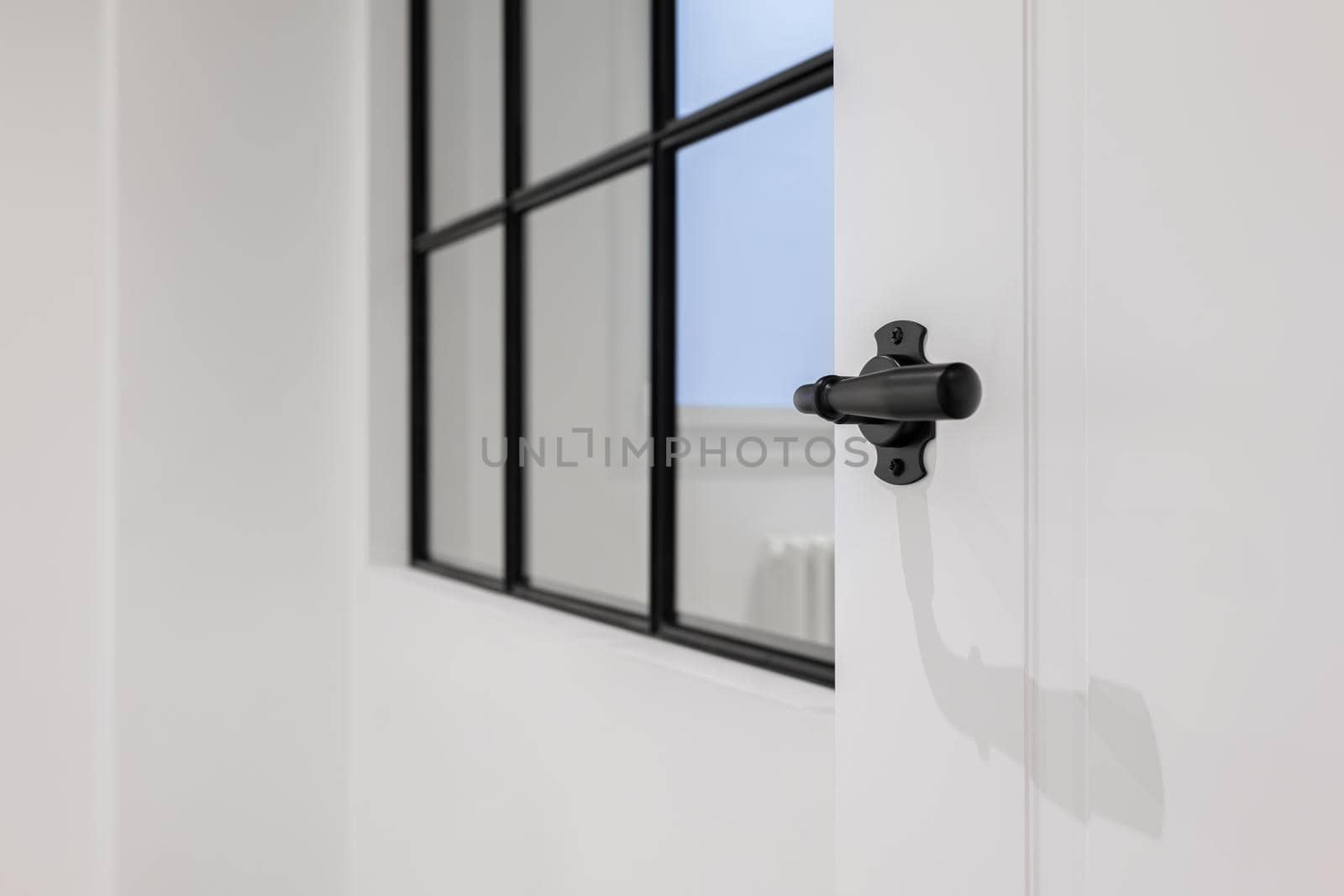 Stylish black door handle in white modern apartment or office. Architecture detail. Selective focus