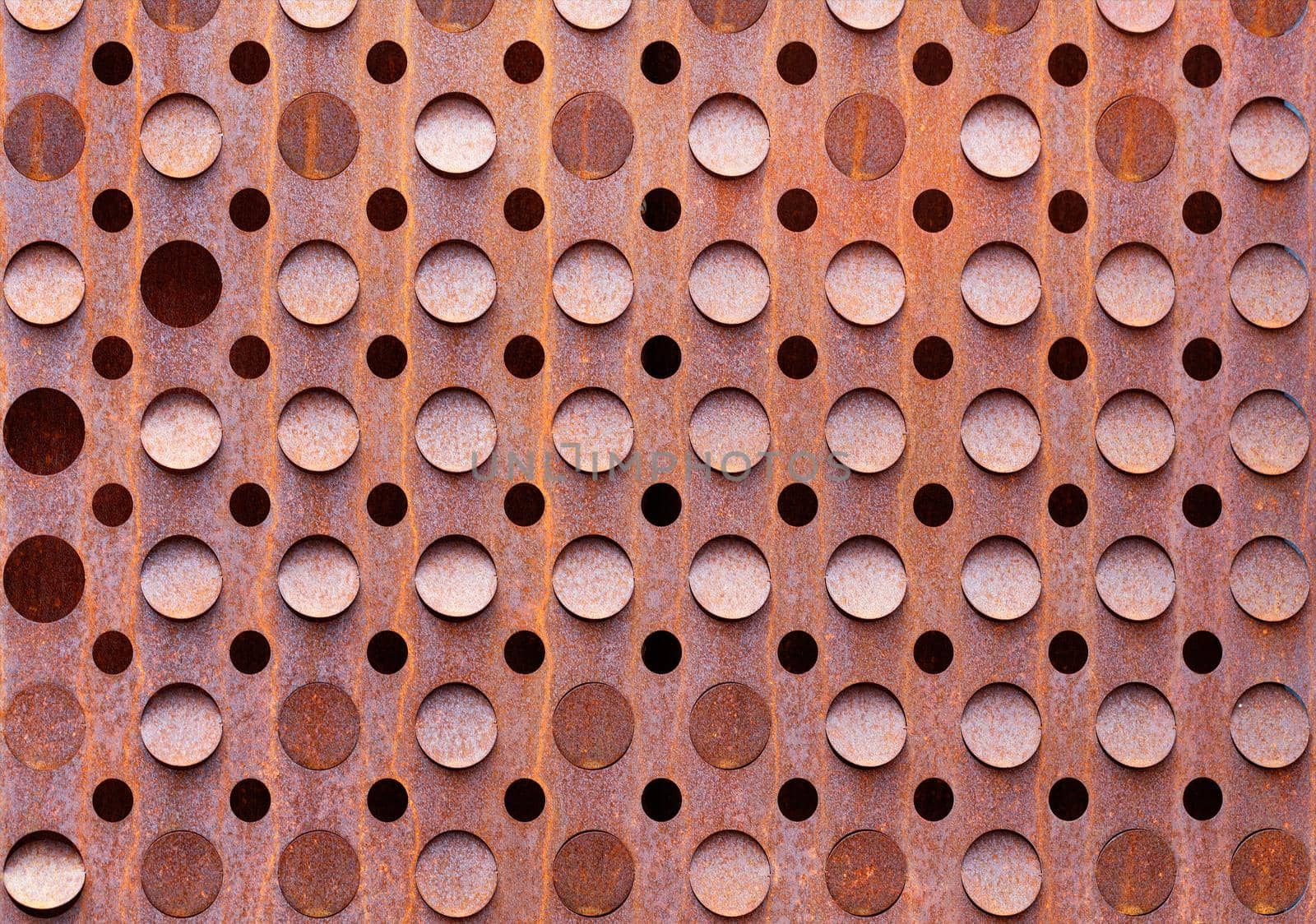 Rust on an old curly sheet of metal texture with round holes. by Sergii