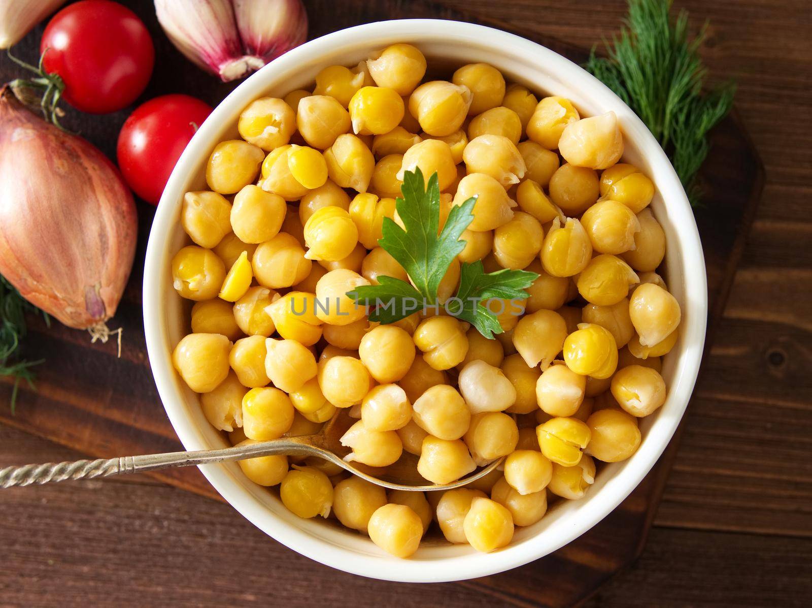 Cooked Chickpeas on bowl on a dark wooden table. Healthy, vegetarian nutritious protein food of Middle East. Top view.