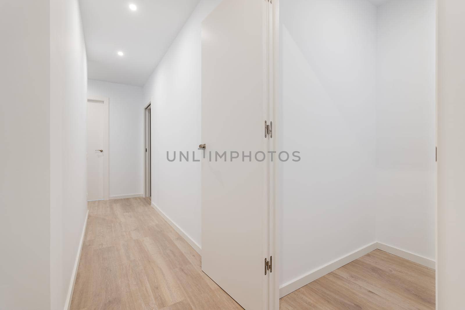 Empty white room with corridor leading to other rooms. Apartment after renovation