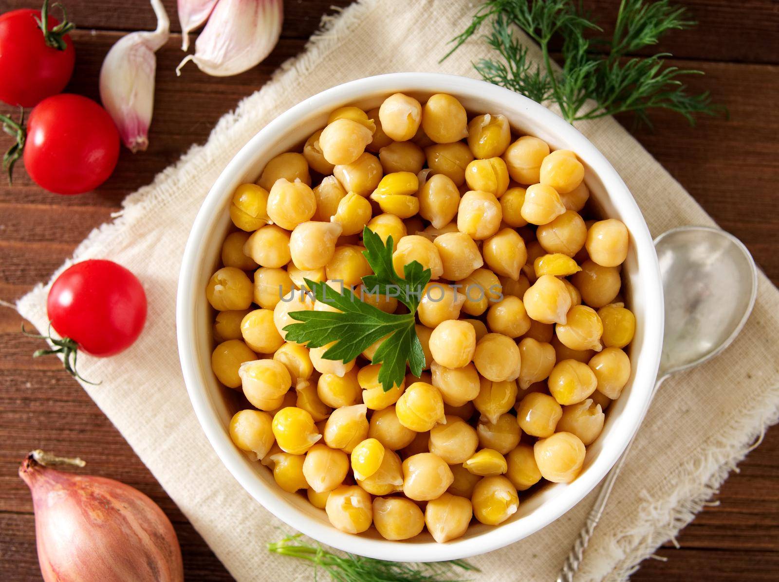 Cooked Chickpeas on bowl on a dark wooden table. Healthy, vegetarian nutritious protein food of Middle East. Top view.