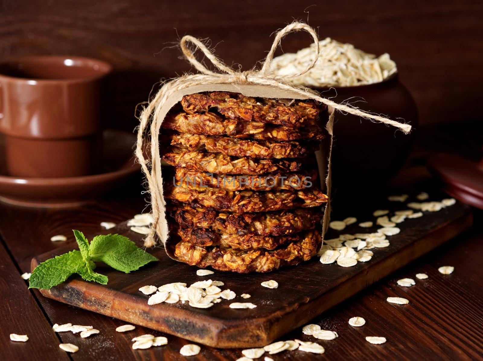 Homemade oatmeal cookies with banana, oats, nuts, eggs and flour free on a brown dark wooden table, side view.