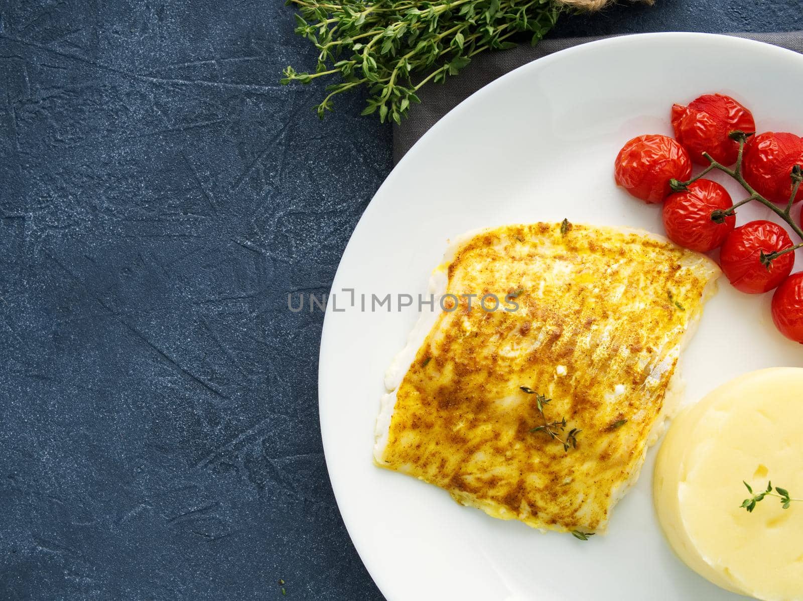 Fish cod baked in oven with mashed potatoes, tomatoes, diet healthy food. Dark gray background by NataBene