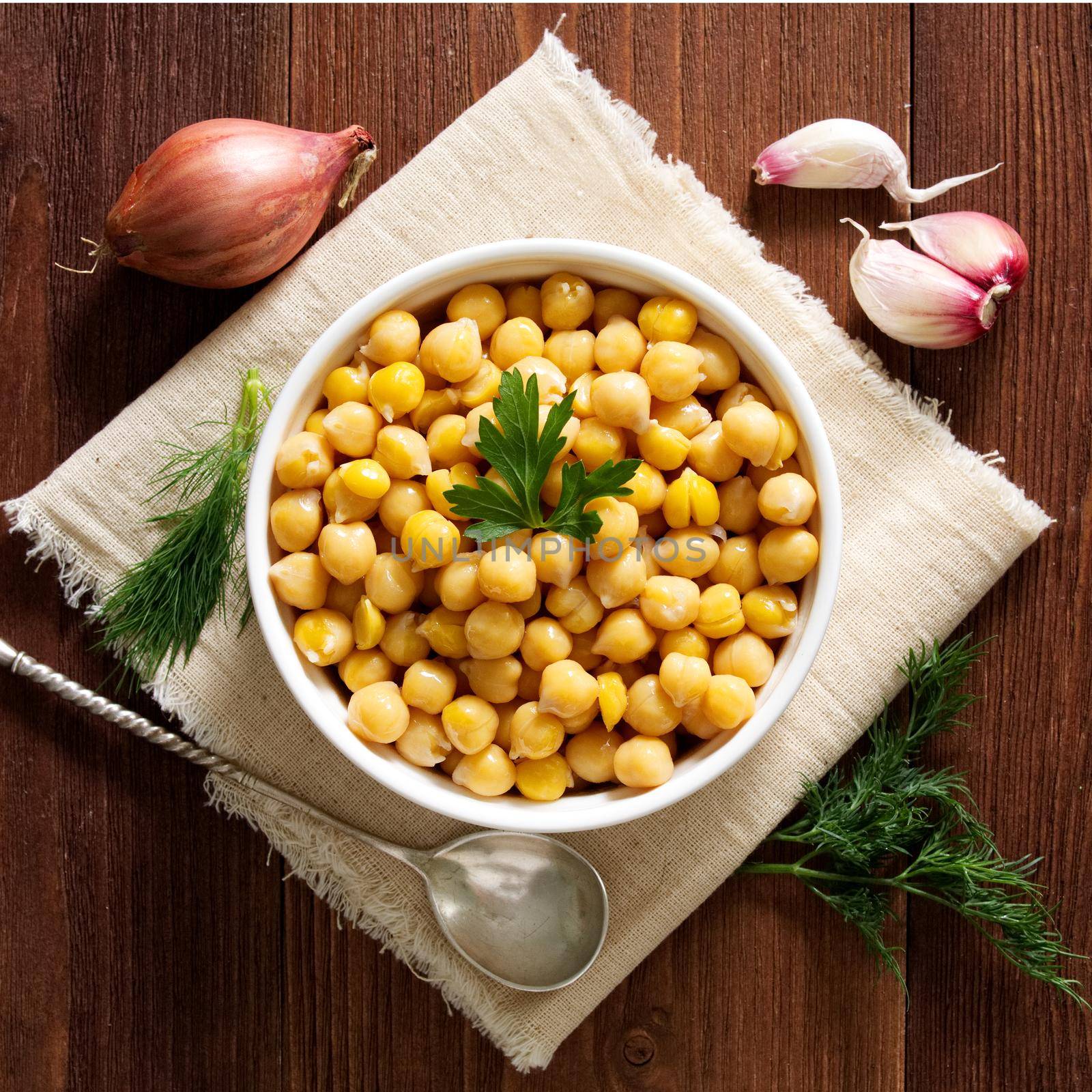 Cooked Chickpeas on bowl on a dark wooden table. Healthy, vegetarian nutritious protein food of Middle East. Top view.