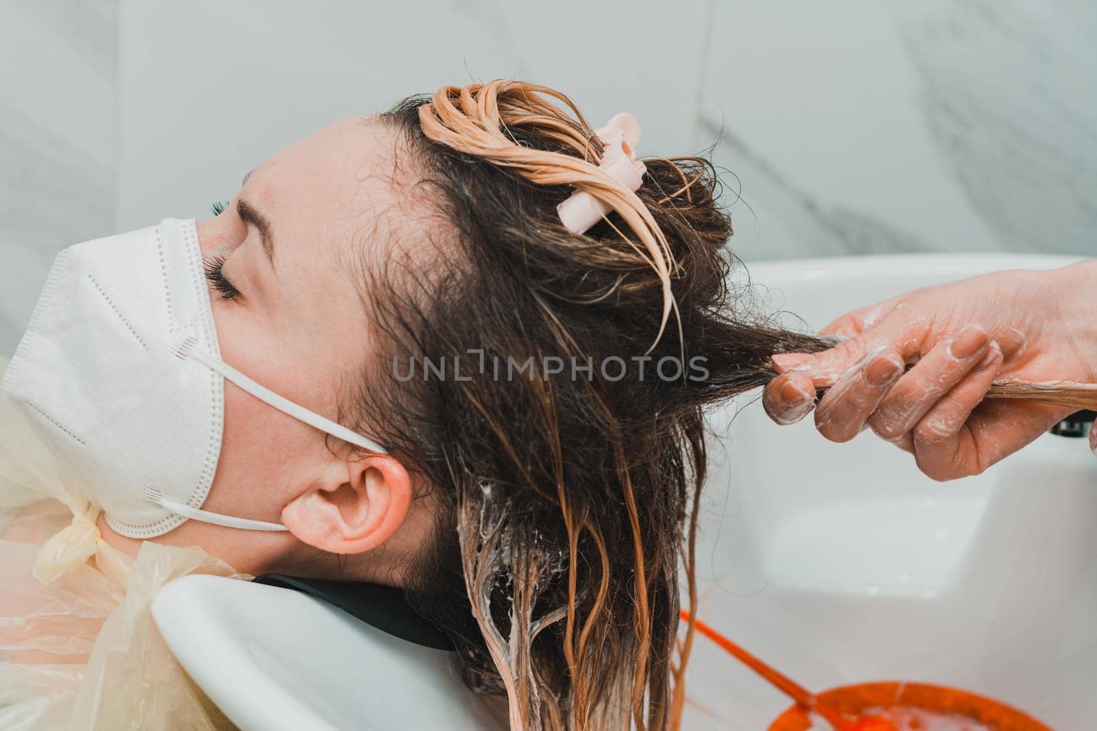 Applying conditioner after shampoo, hair care in the salon, balayage technique by Niko_Cingaryuk