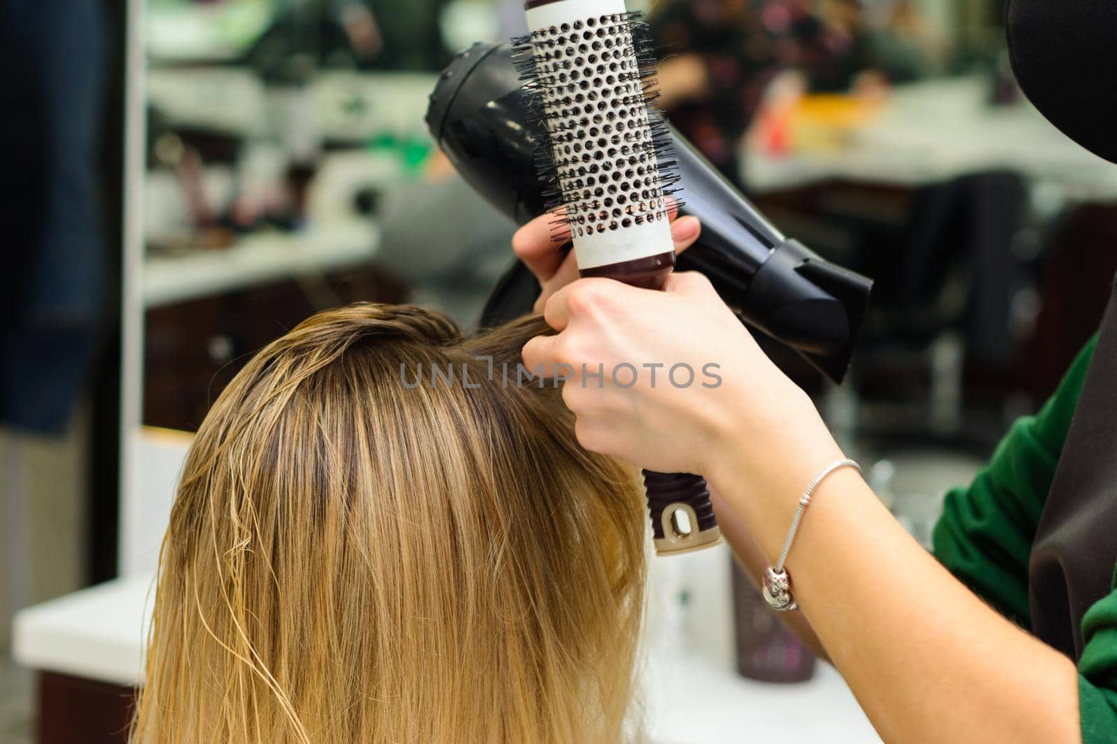 Drying hair with a hair dryer and a round brush, hairdressing procedures. new
