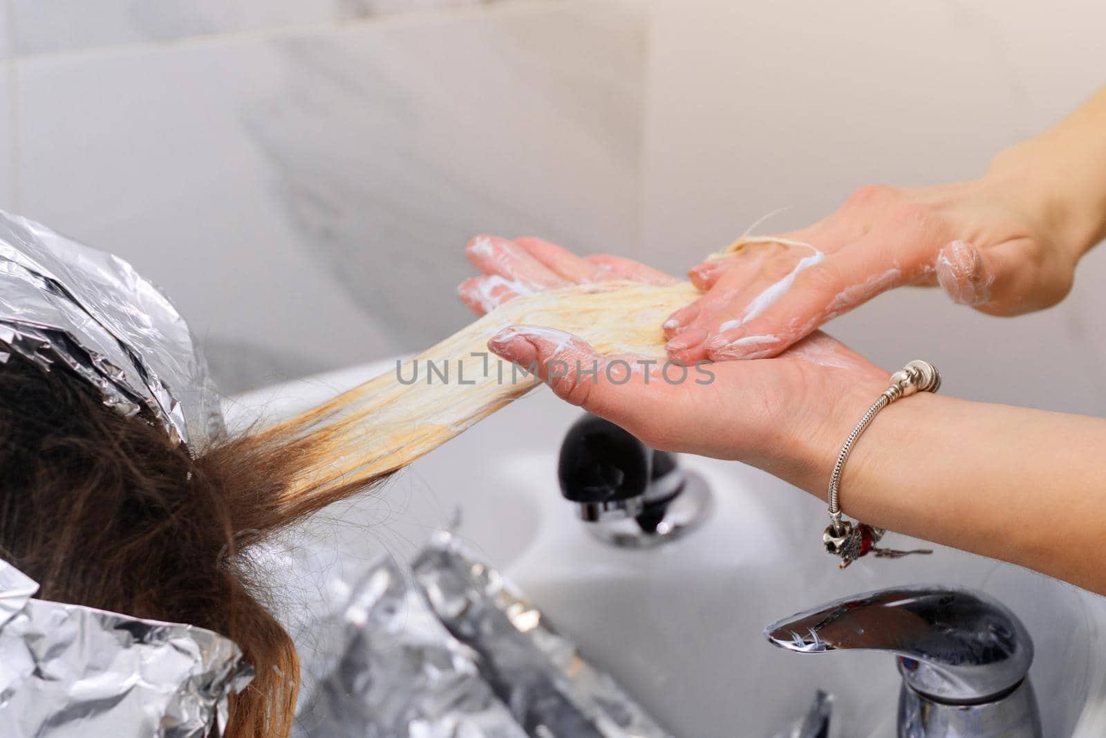Washing hair dye from a hairdresser, removing foil from hair. new
