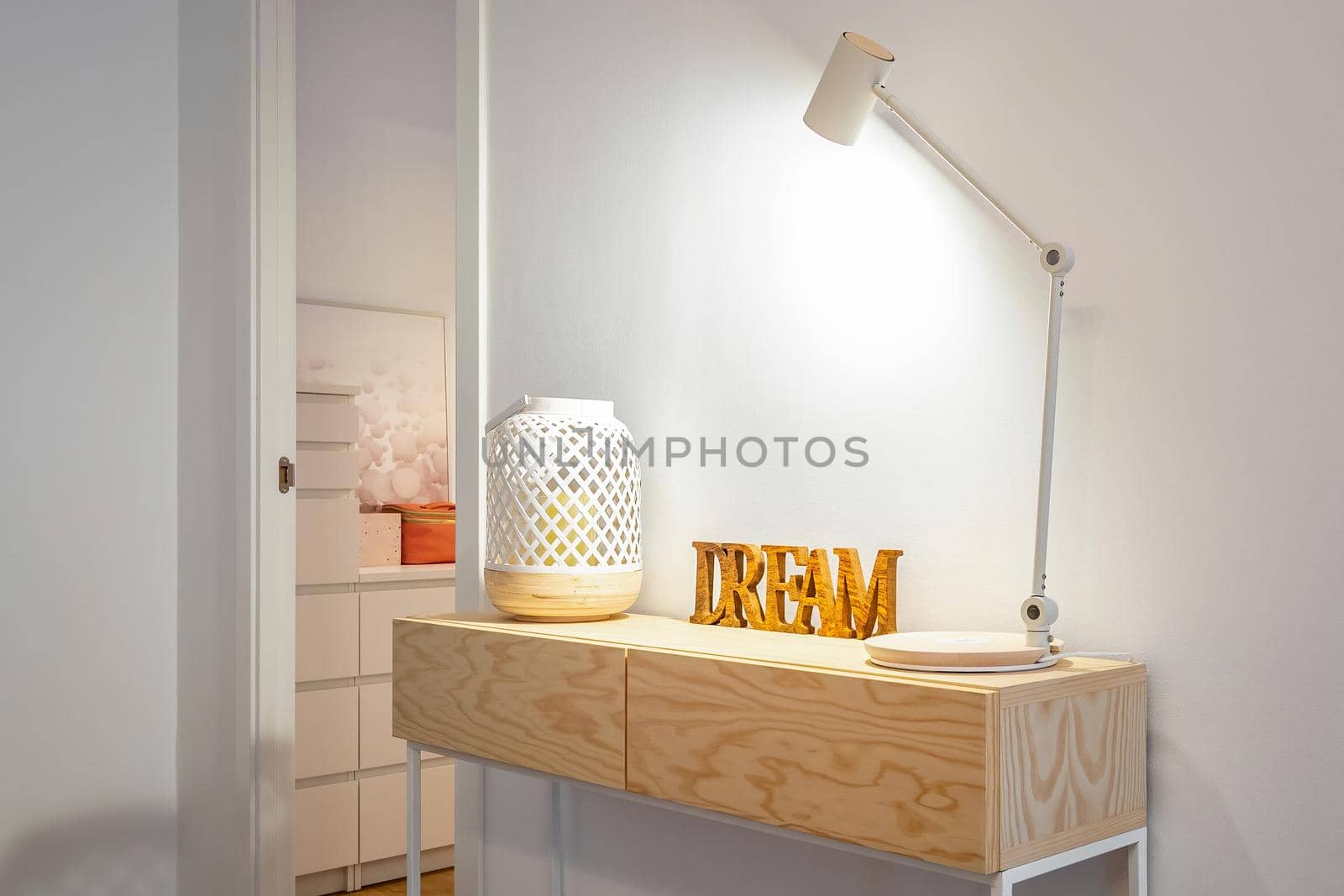 Table lamp, candle holder and wooden word Dream at home with a room at the background
