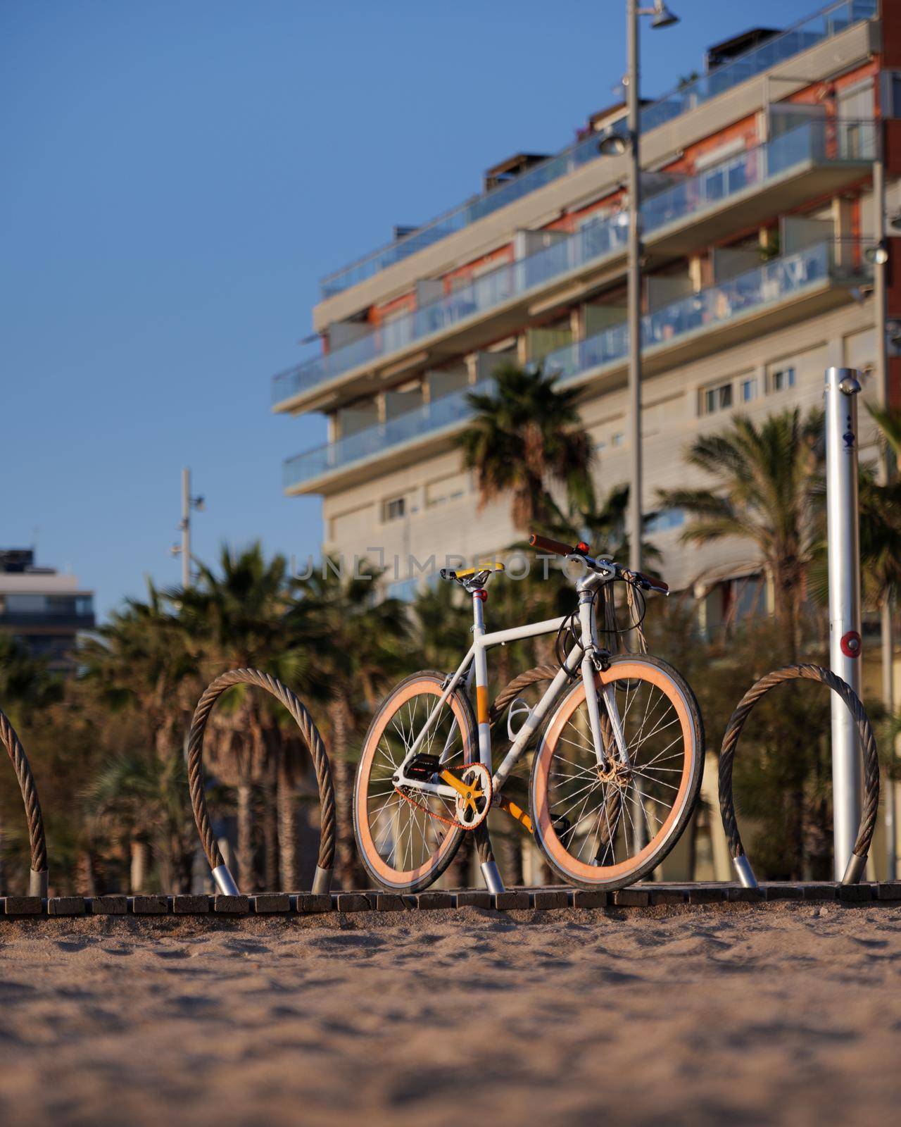 Bicycle with orange wheels parcked at the beach during sunny day. by apavlin