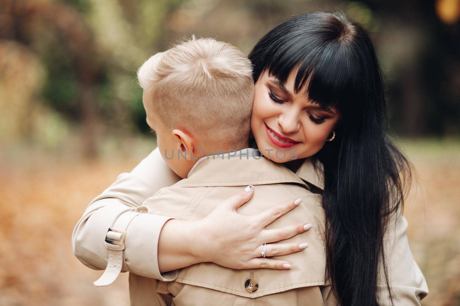 Mom and son are on good terms, walking in the park, chatting. Stylish family, family look by StudioLucky