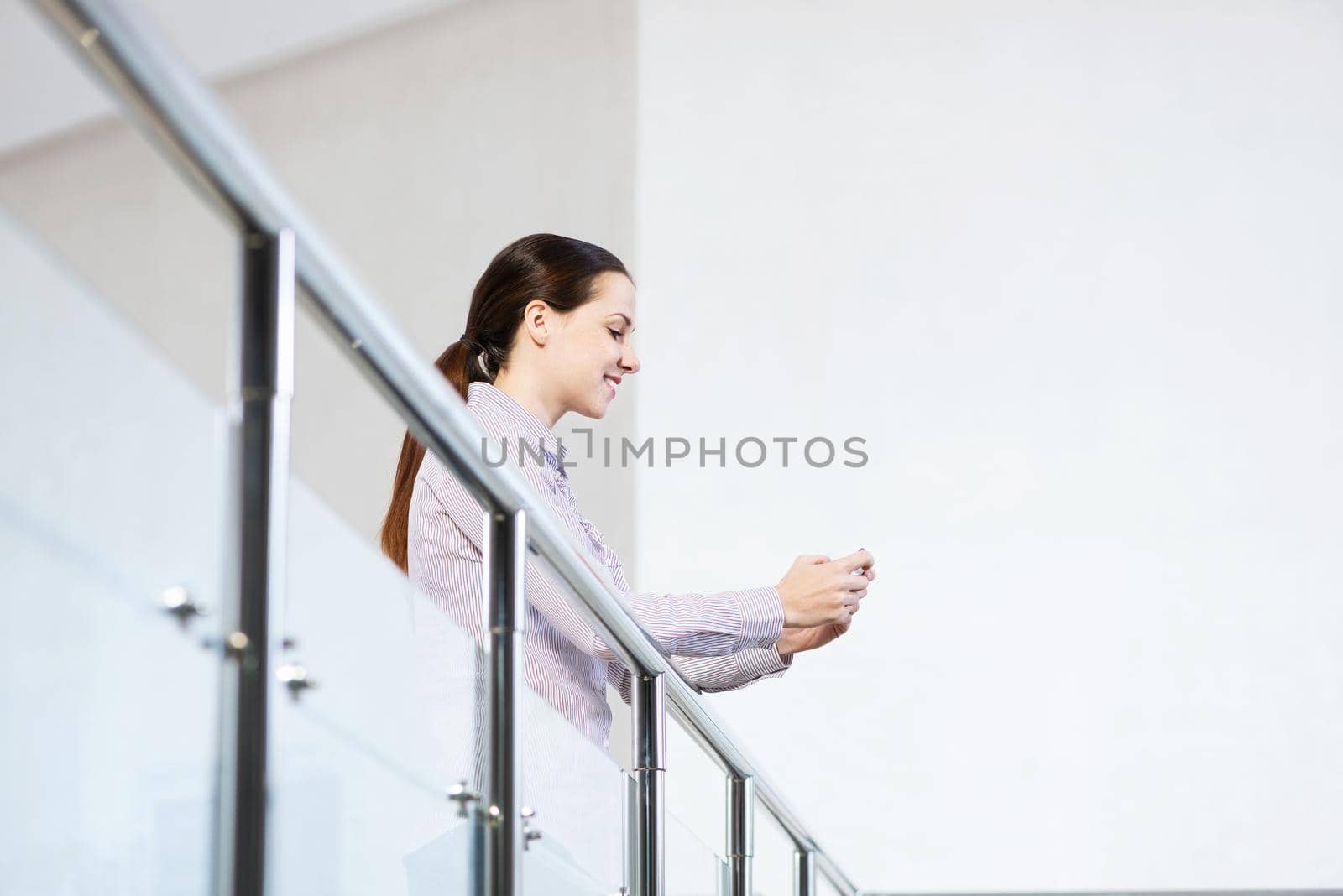 A young woman holds a cell phone. typing in a smartphone.