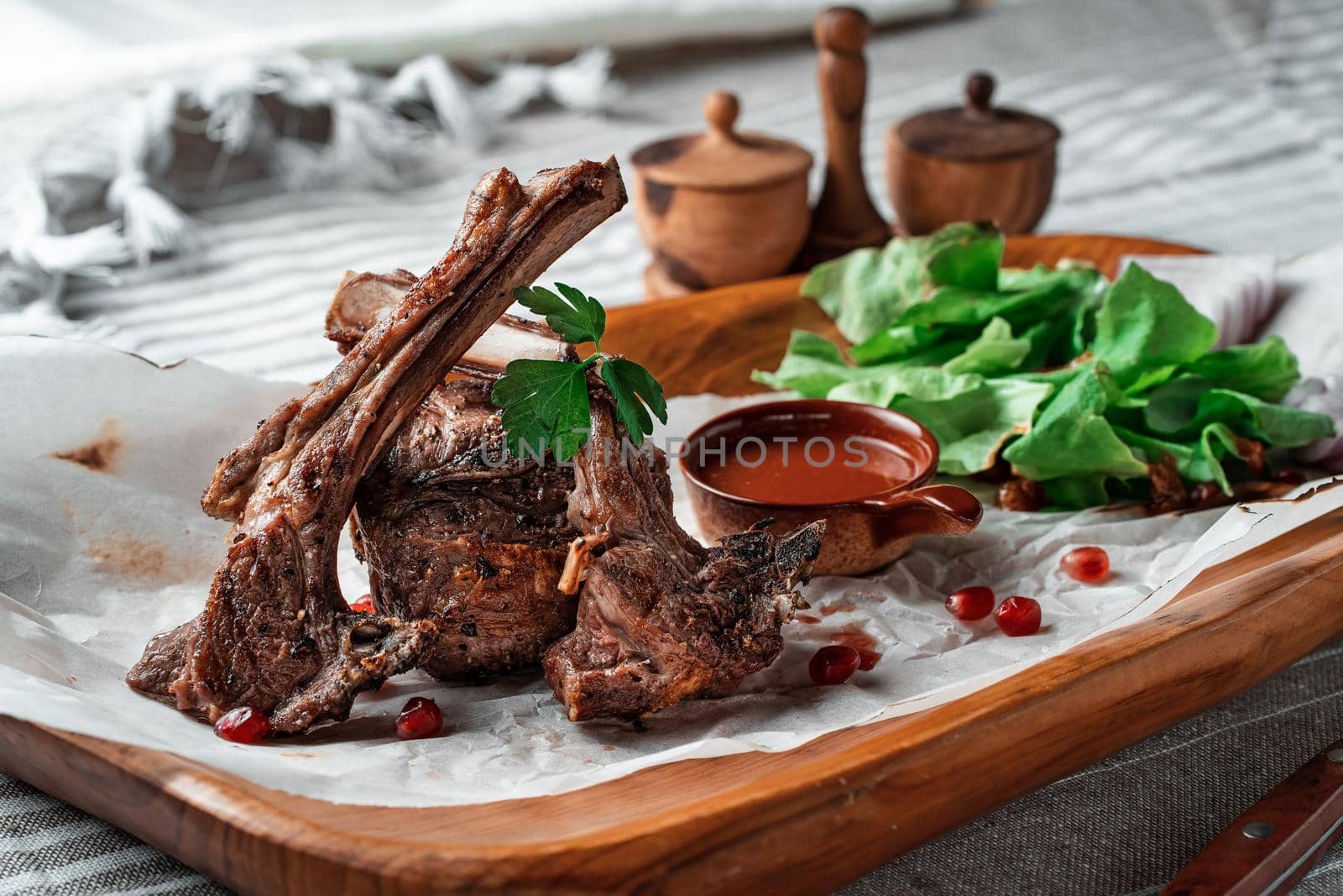 Grilled lamb loin on a wooden plate with lettuce leaves. High quality photo