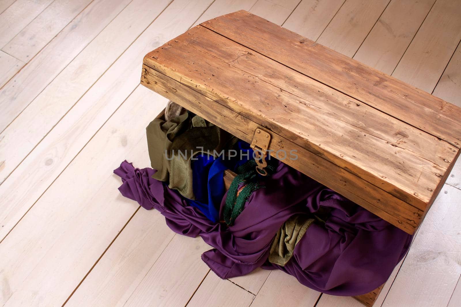 vintage wooden chest with tissues on a wooden floor. Top view.