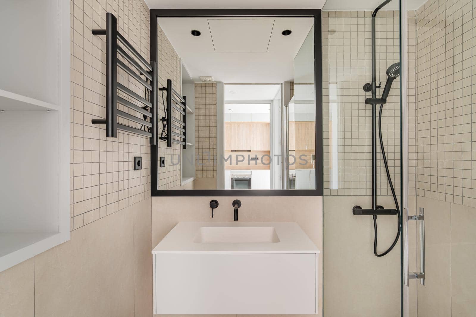 Modern interior design of bathroom in beige with black metal decoration. Front view of mirror and sink in refurbished apartment