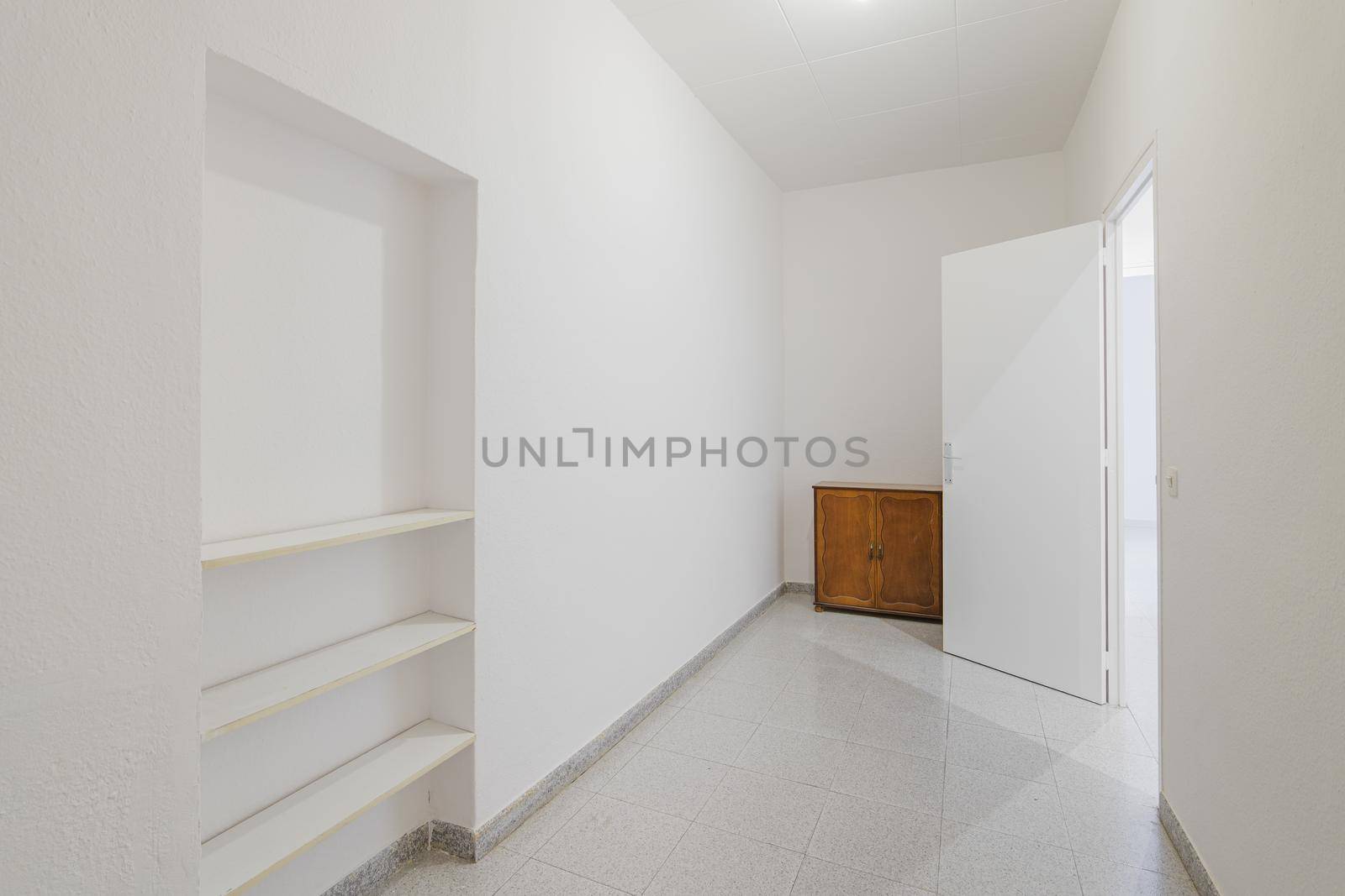 Empty small room with white walls and built-in niche for shelves in an old flat before renovation. by apavlin
