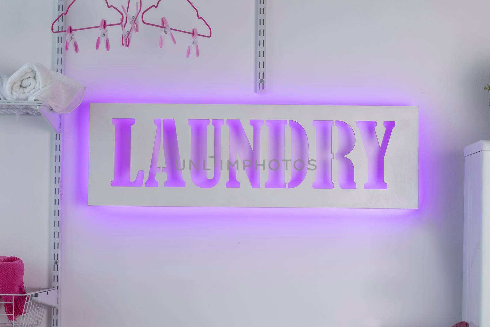 Glowing neon laundry sign on a white background. Illuminated signboard self-service laundry.