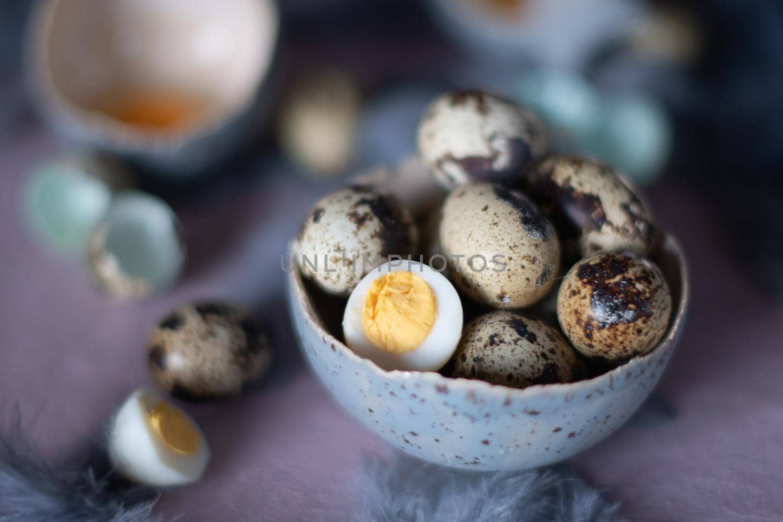quail eggs in ceramic vases, gray feathers on the table, easter still life, natural food, diet and antioxidants, dark key and shallow depth of field. High quality photo