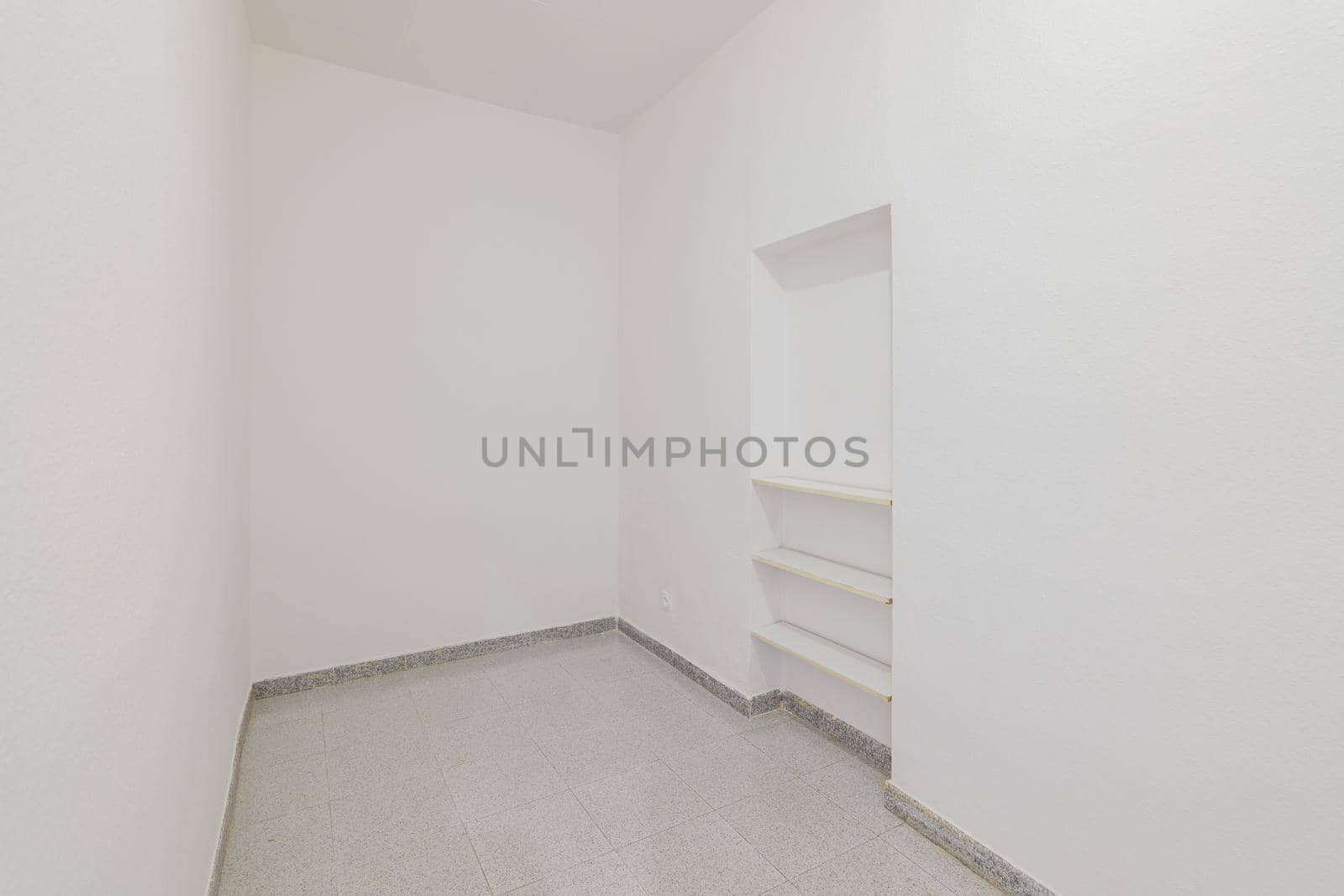 Empty small room with white walls and built-in niche for shelves in an old flat before renovation. by apavlin