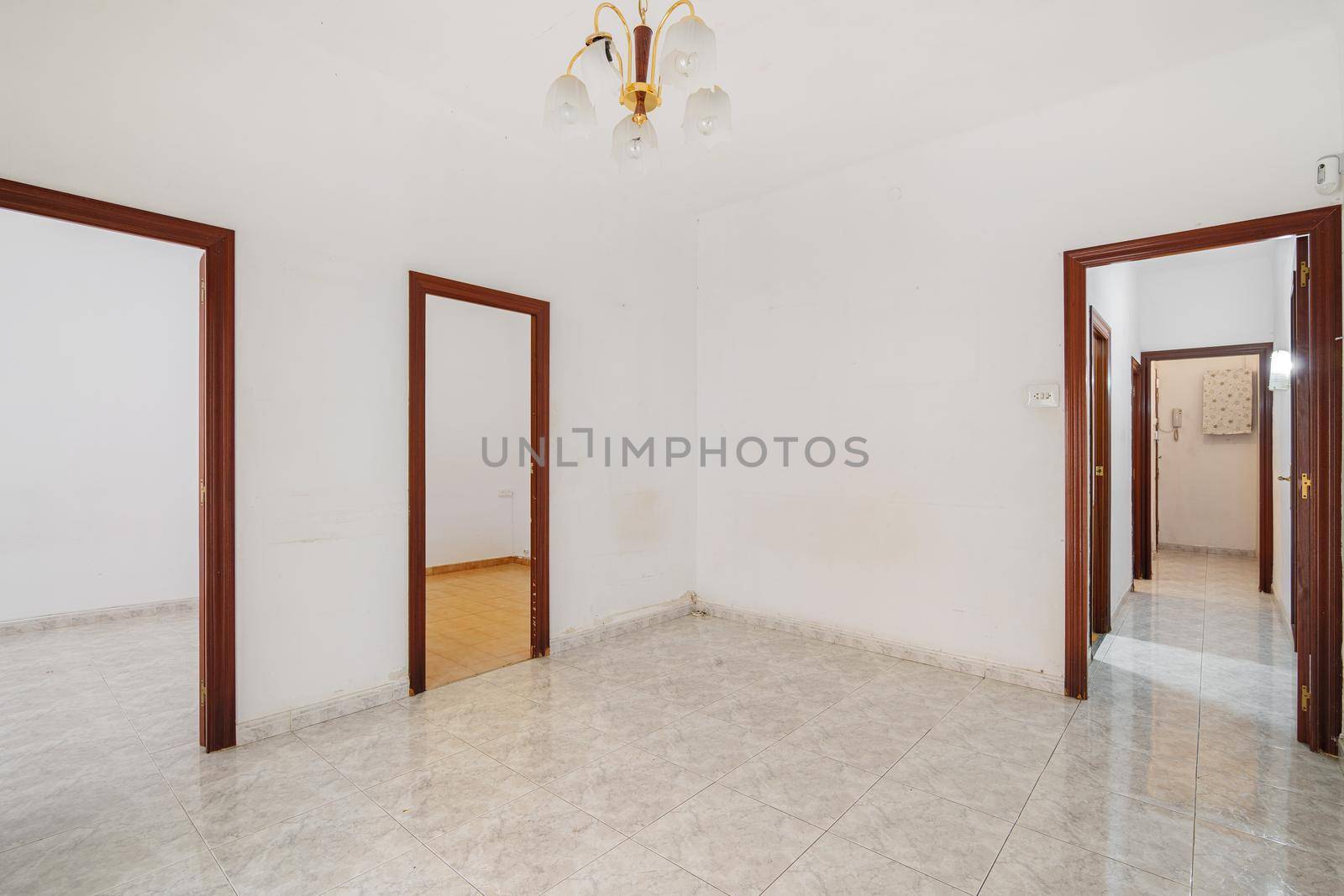 Empty white hall with long corridor and doors leading to other rooms. Typical apartment in Barcelona for rent or sale