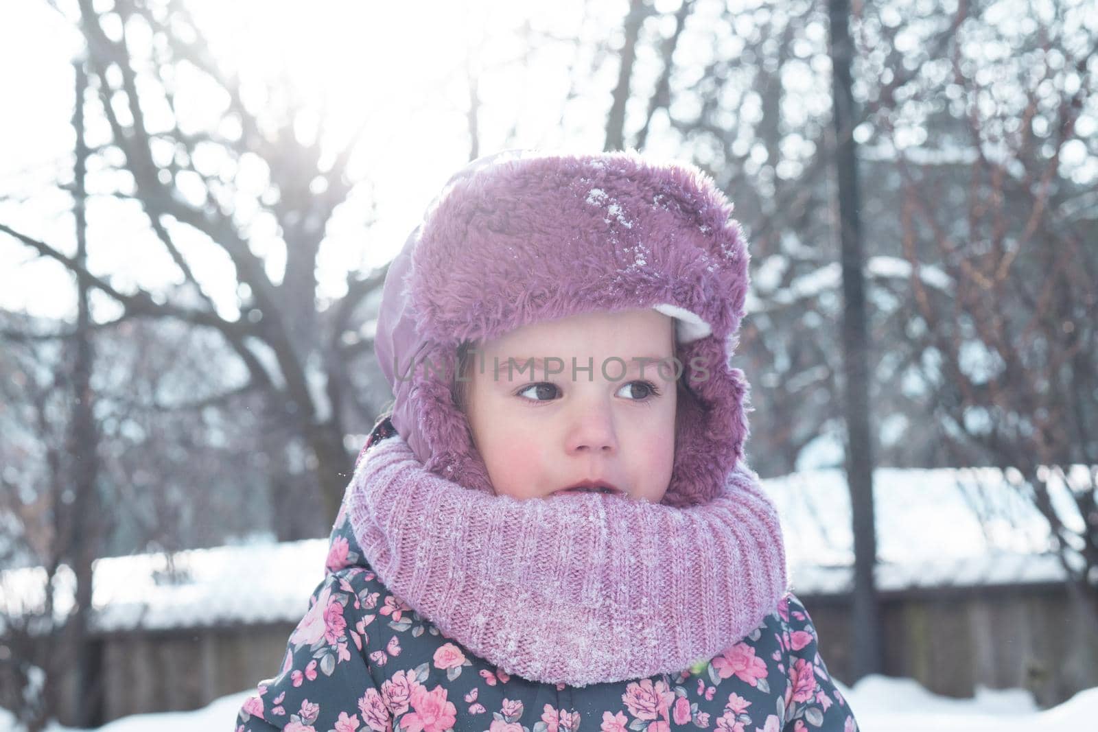 Winter, family, childhood concepts - close-up portrait authentic little preschool minor 3-4 years girl in pink hat look at camera posing smile in snowy frosty weather. happy kid face have fun outdoors.