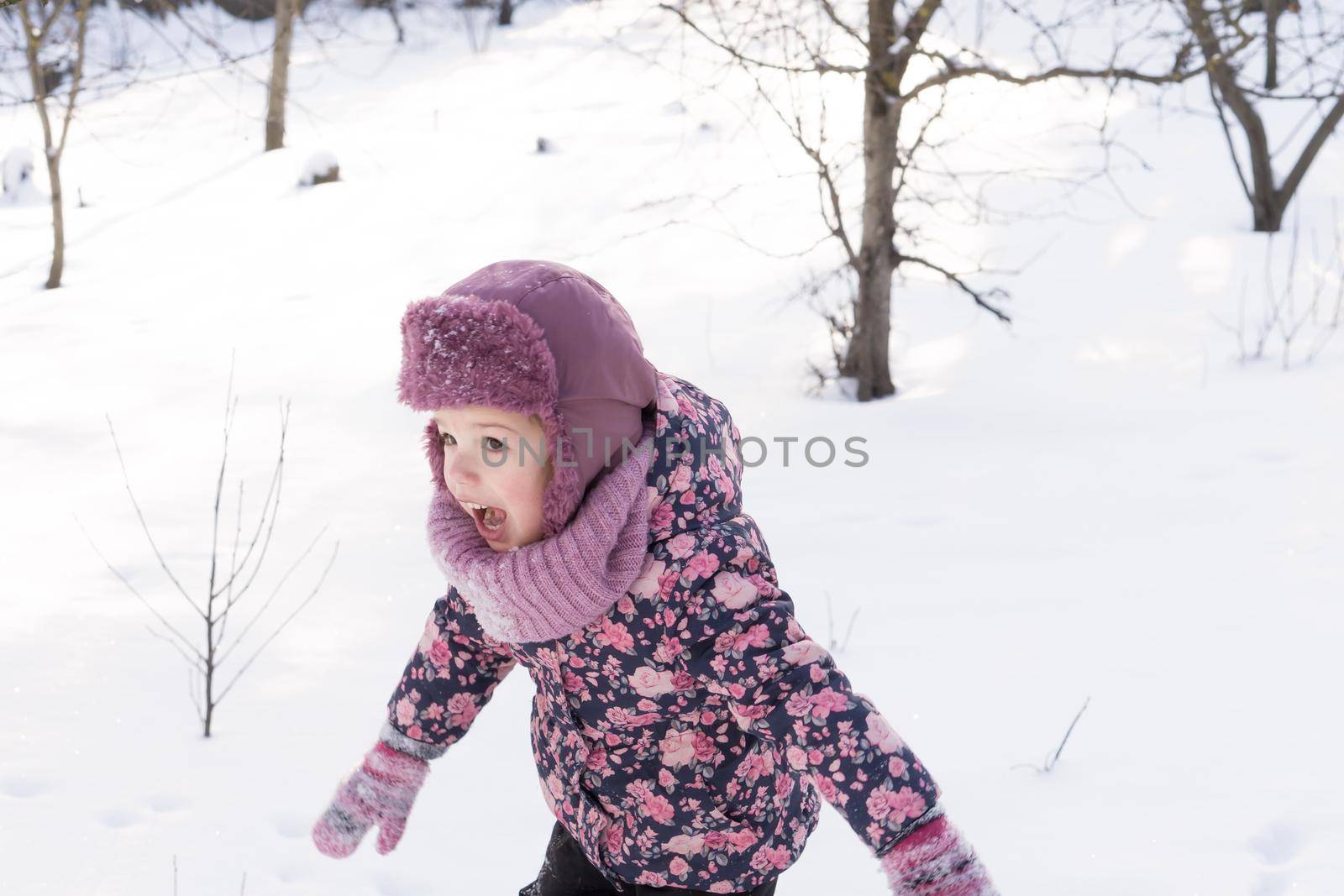 Winter, family, childhood concepts - authentic little preschool minor baby girl in pink warm clothes walking in snowy frosty cold weather day in park. happy pretty cute kid have fun joy run outdoors by mytrykau