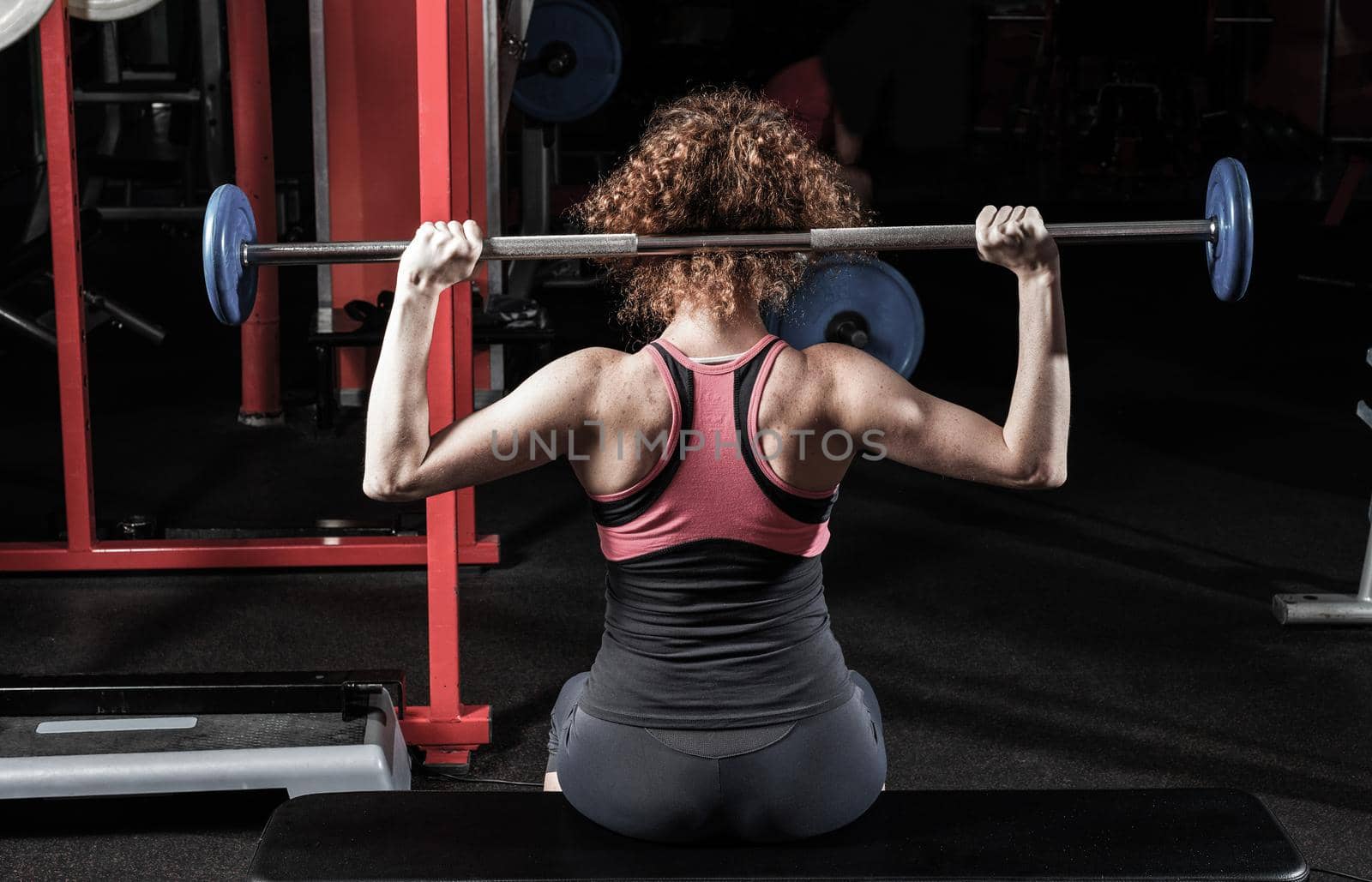 Woman bodybuilder engaged with a barbell in the gym. Healthy lifestyle.