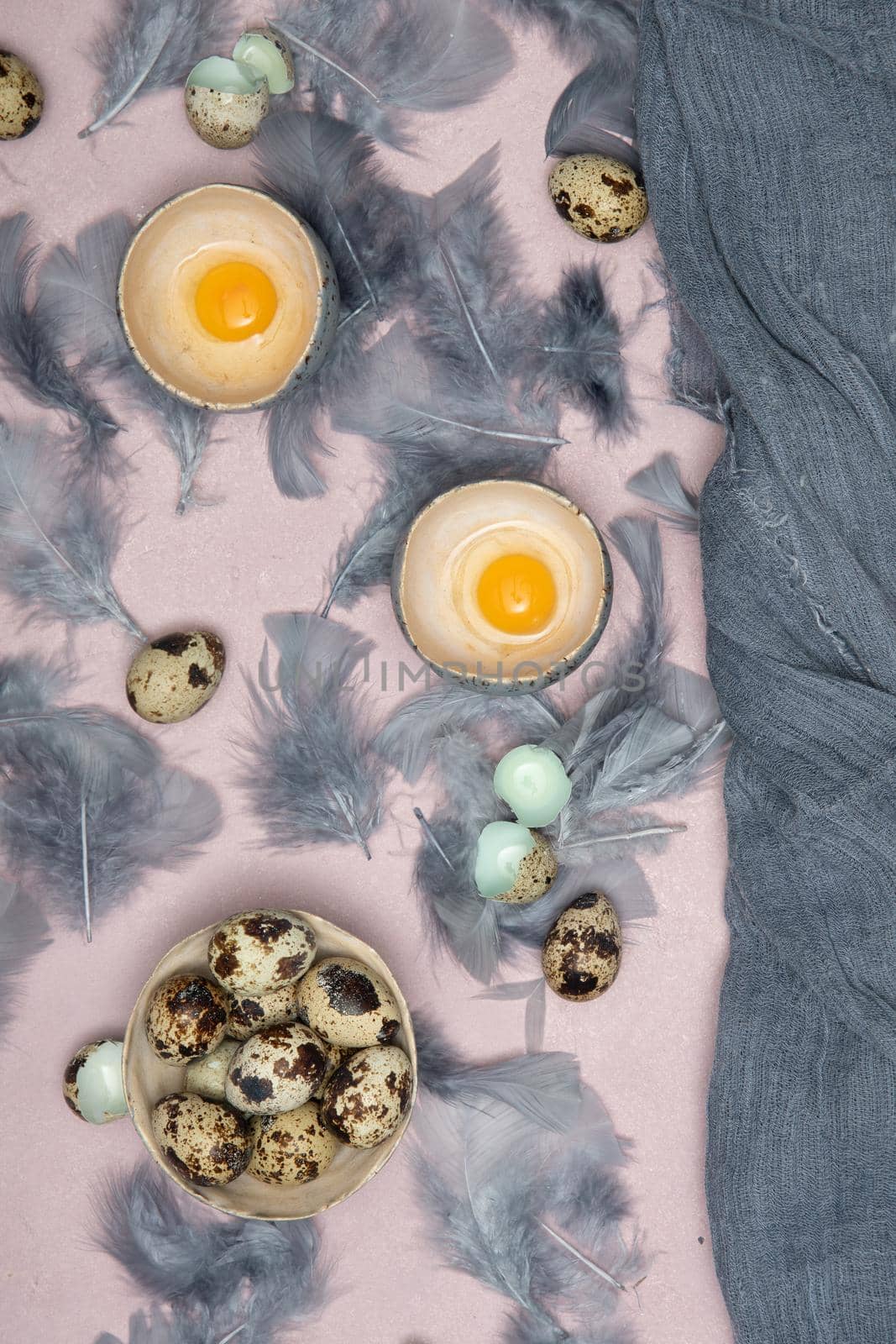 quail eggs in ceramic vases, gray feathers on the table, easter still life, natural food, diet and antioxidants, dark key and shallow depth of field. High quality photo