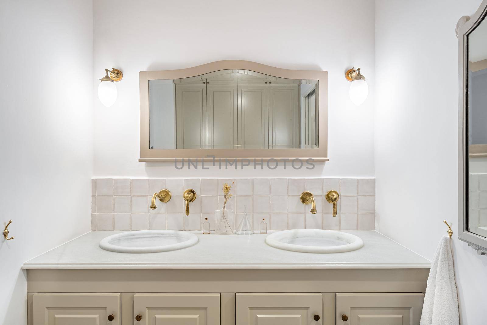 Bathroom decorated in beige color with two sinks, golden faucets and vintage mirror. Interior of retro or classic style. by apavlin