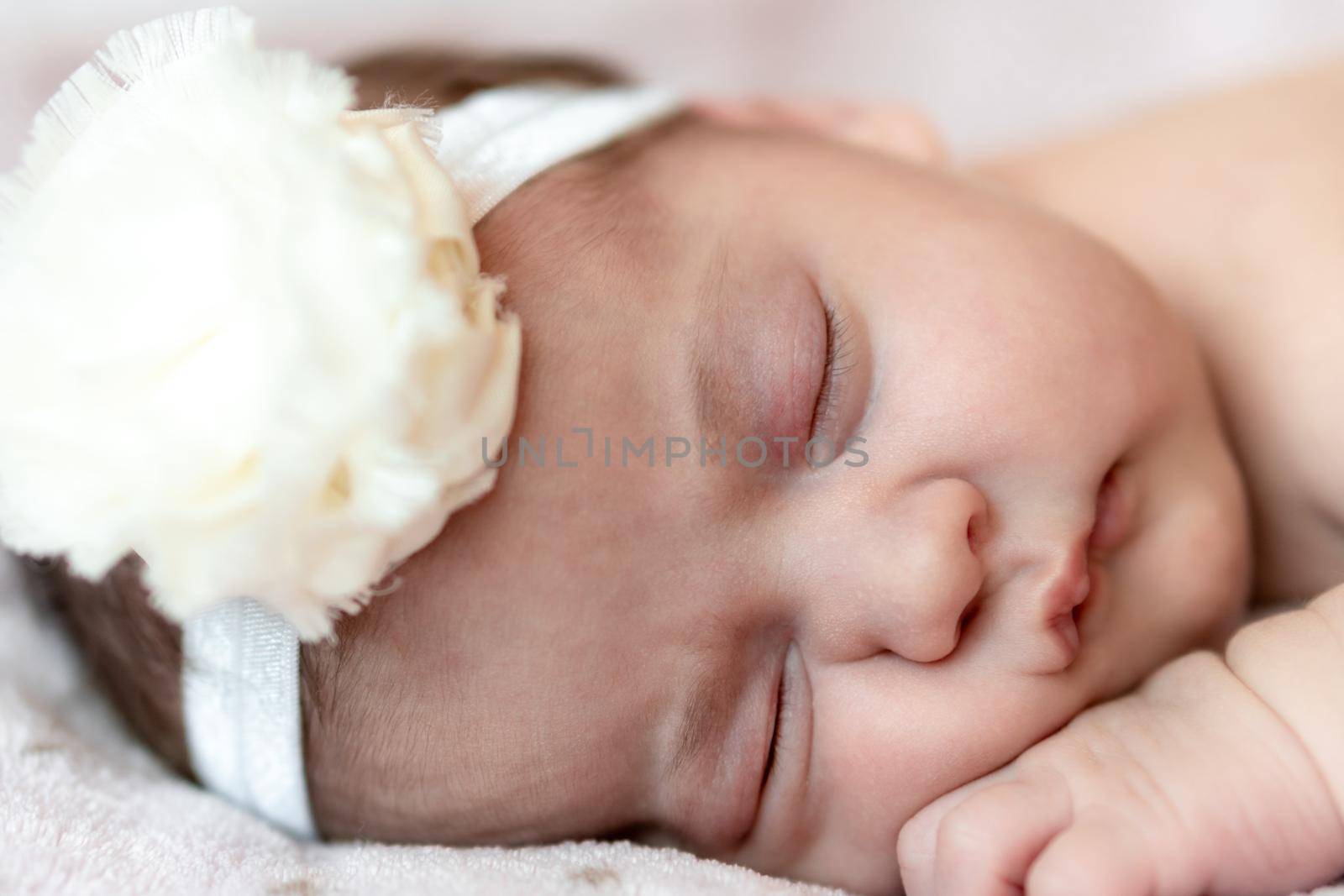 Childhood, care, motherhood, health, medicine, pediatrics concepts - Close up Little peace calm naked infant newborn baby girl in pink hat sleeps resting take deep nap laying on tummy on soft bed.