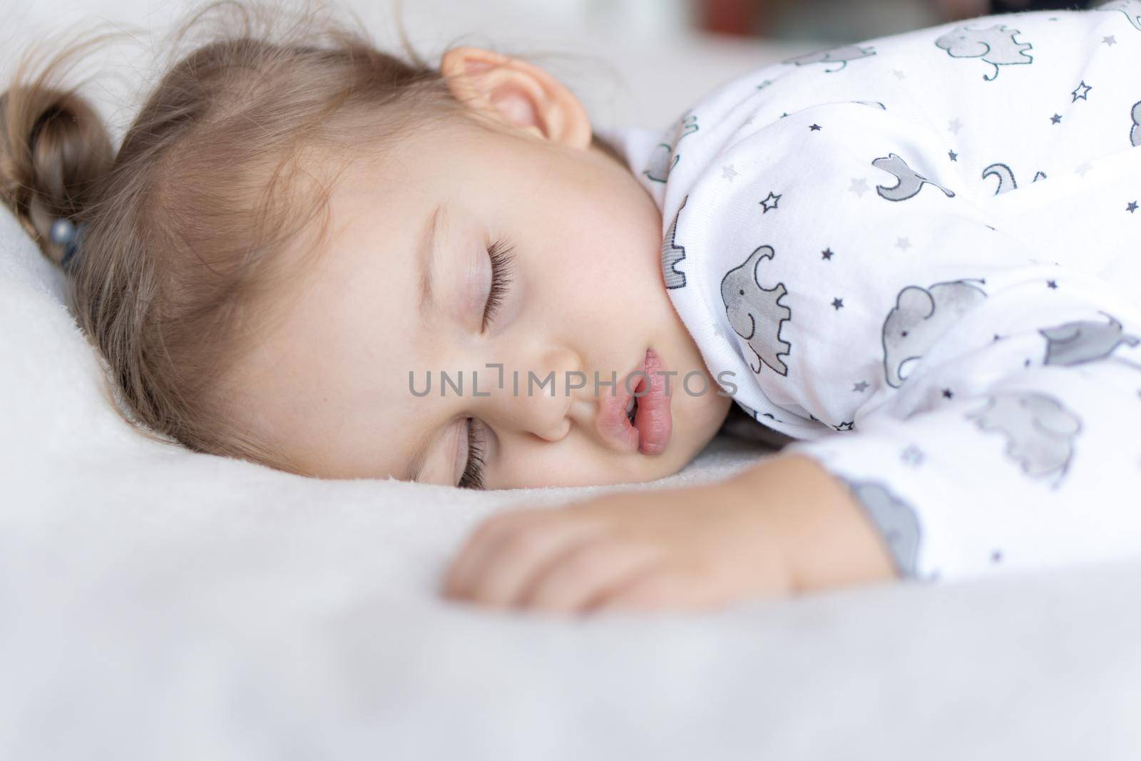 Childhood, care, motherhood, health, medicine, pediatrics concepts - Close up Little peace calm todler preschool girl sleeps resting take deep nap laying on tummy on soft bed. bedtime mod close eyes.