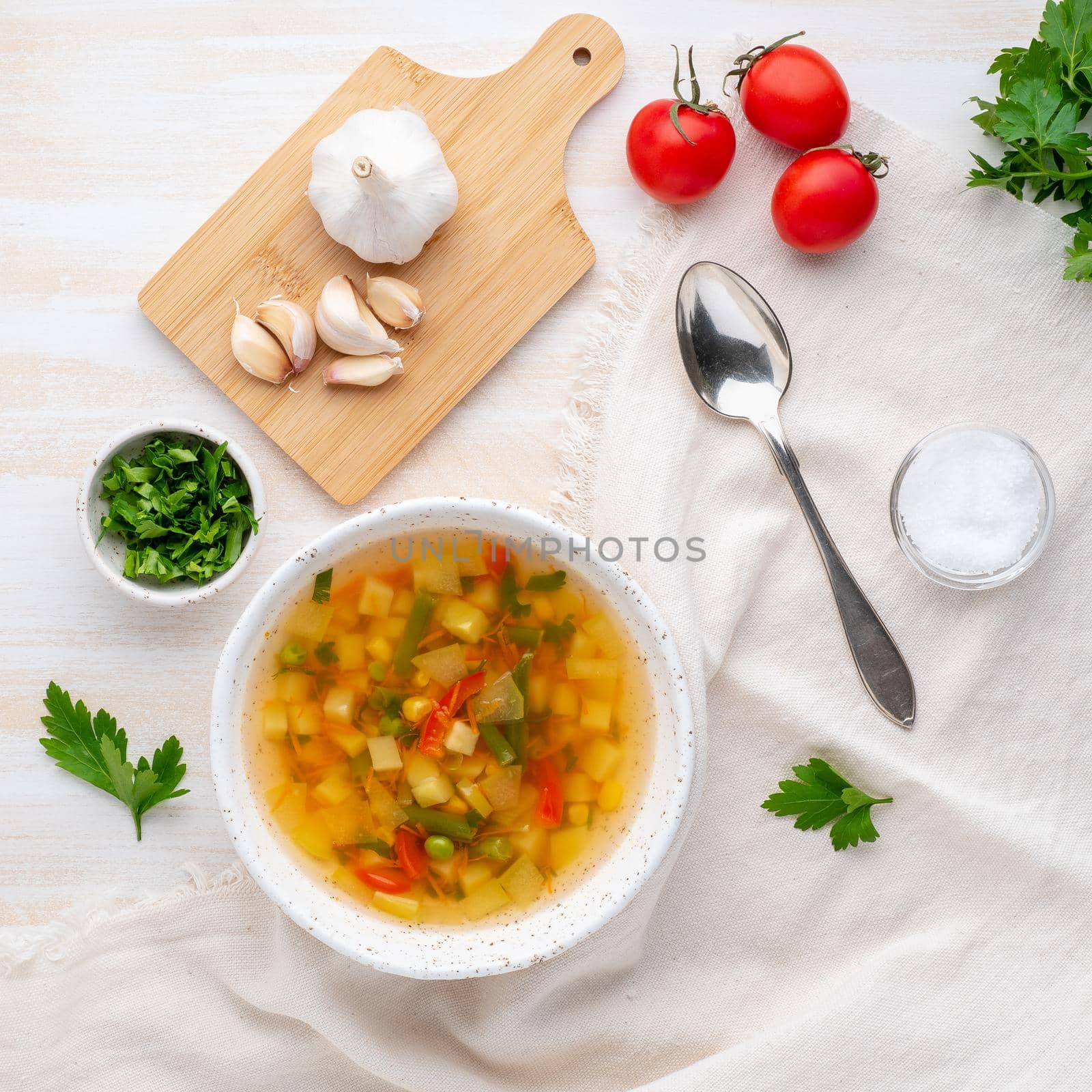 Healthy spring vegetable dietary vegetarian soup, white wooden background, top view, close up by NataBene