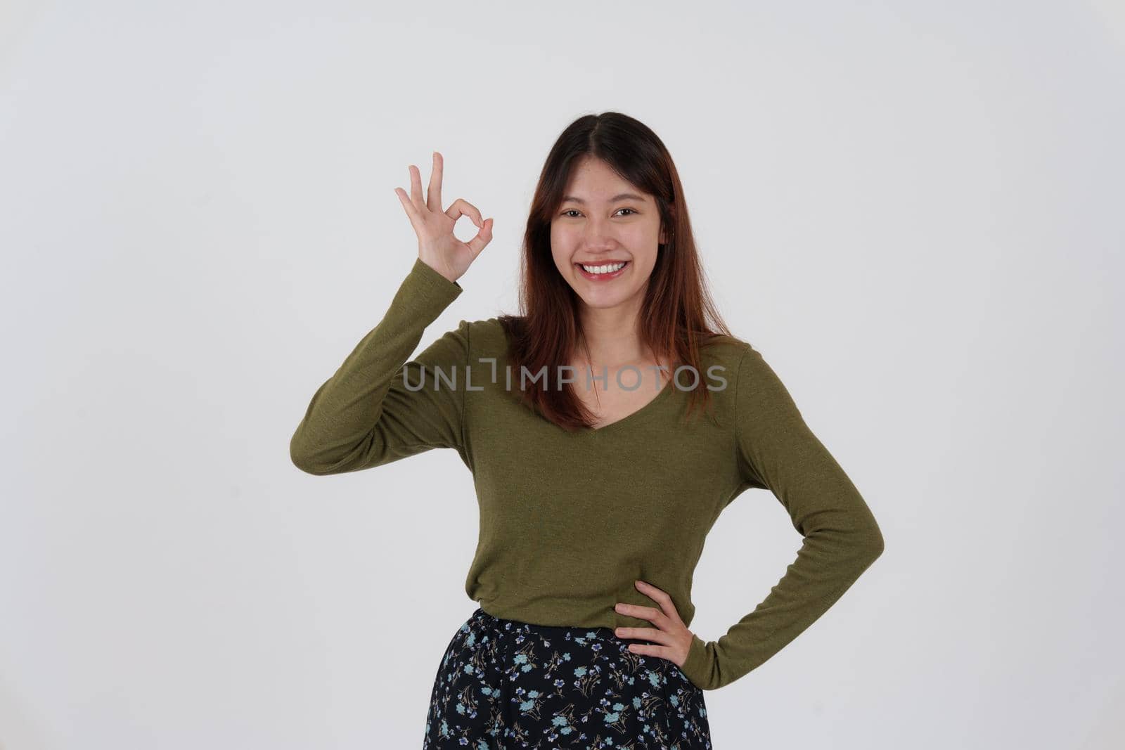 Image of happy young girl standing and Looking camera pointing isolated over white background