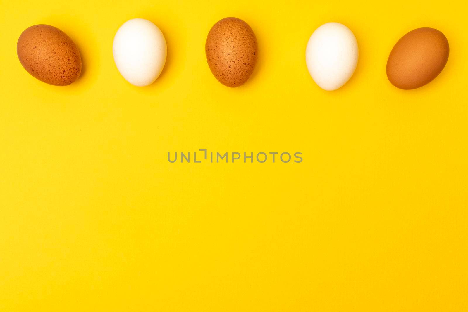 Easter eggs on a yellow background, place for an inscription in the center.