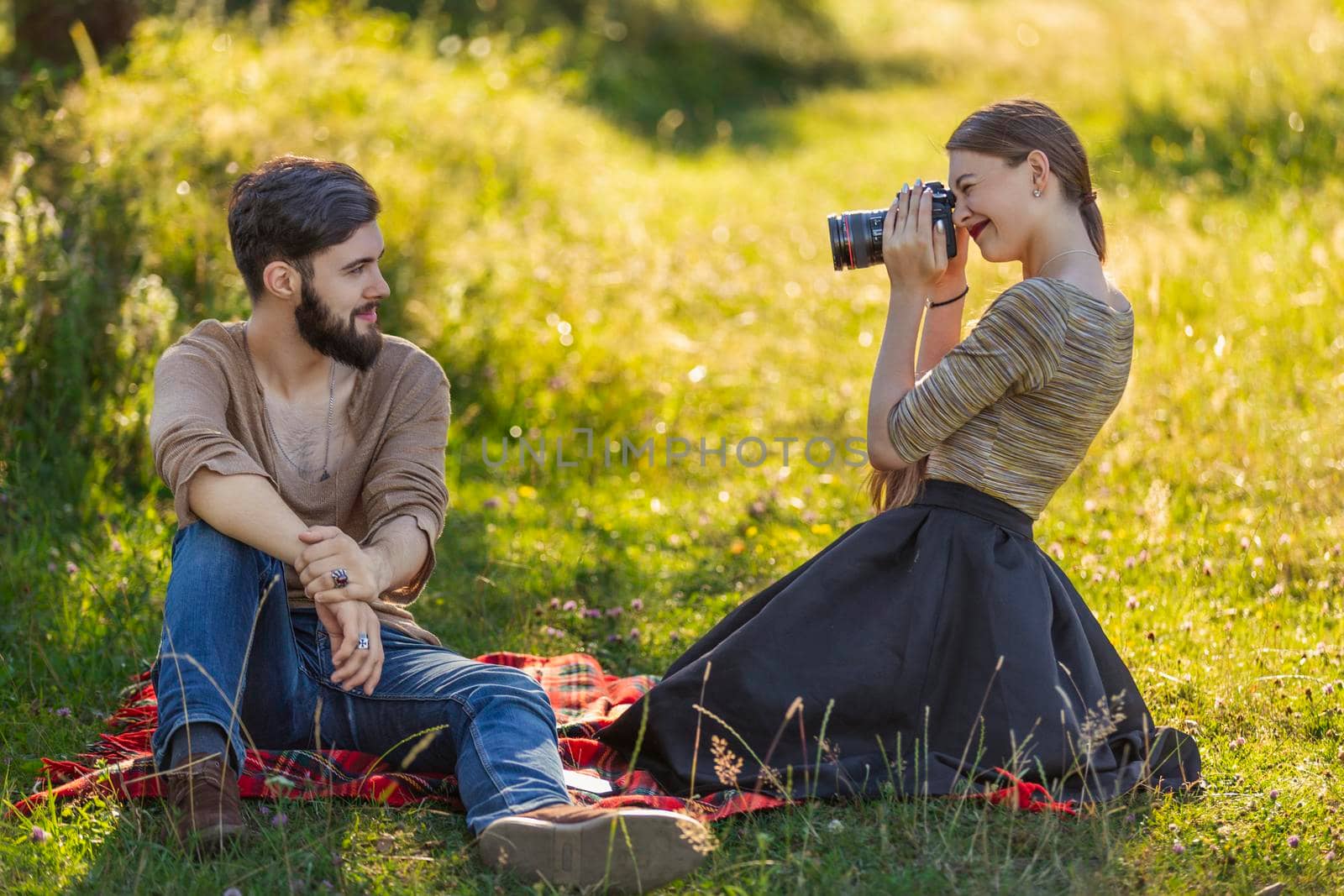 girl photographing her boyfriend in nature