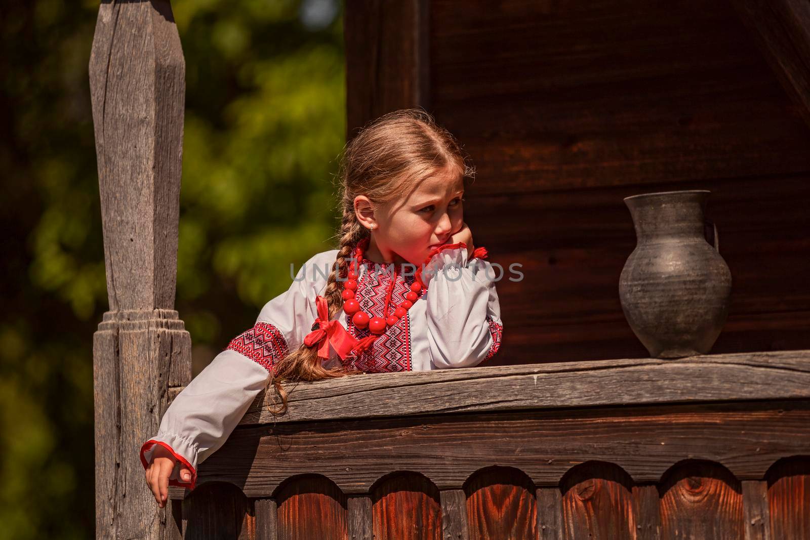 portrait of a girl in a Ukrainian dress who stands near a jug