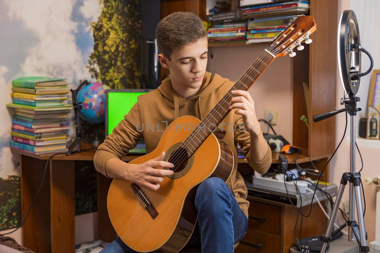 boy playing guitar in his room