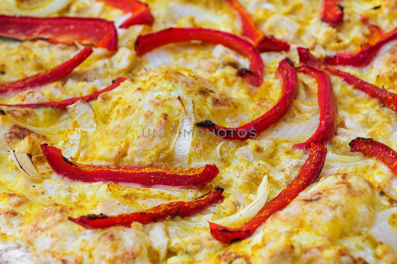 Close-up of pizza topped with red pepper, onion and yellow curry sauce. Macro shot of delicious products. by apavlin