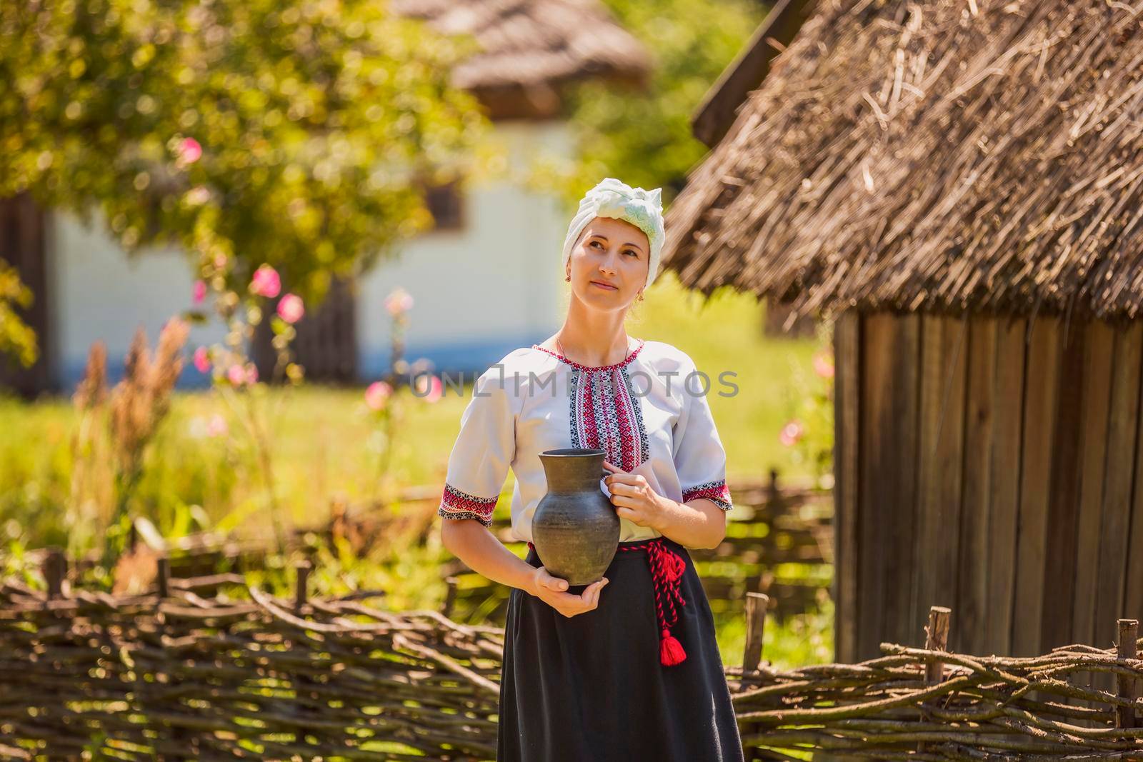 woman in Ukrainian national costume with a jug in her hands on the street