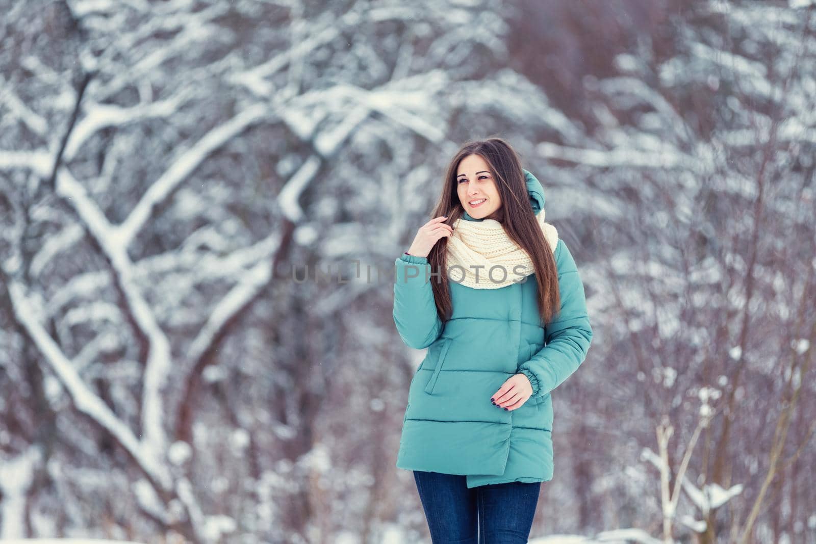 girl in a jacket on the background of snowy trees