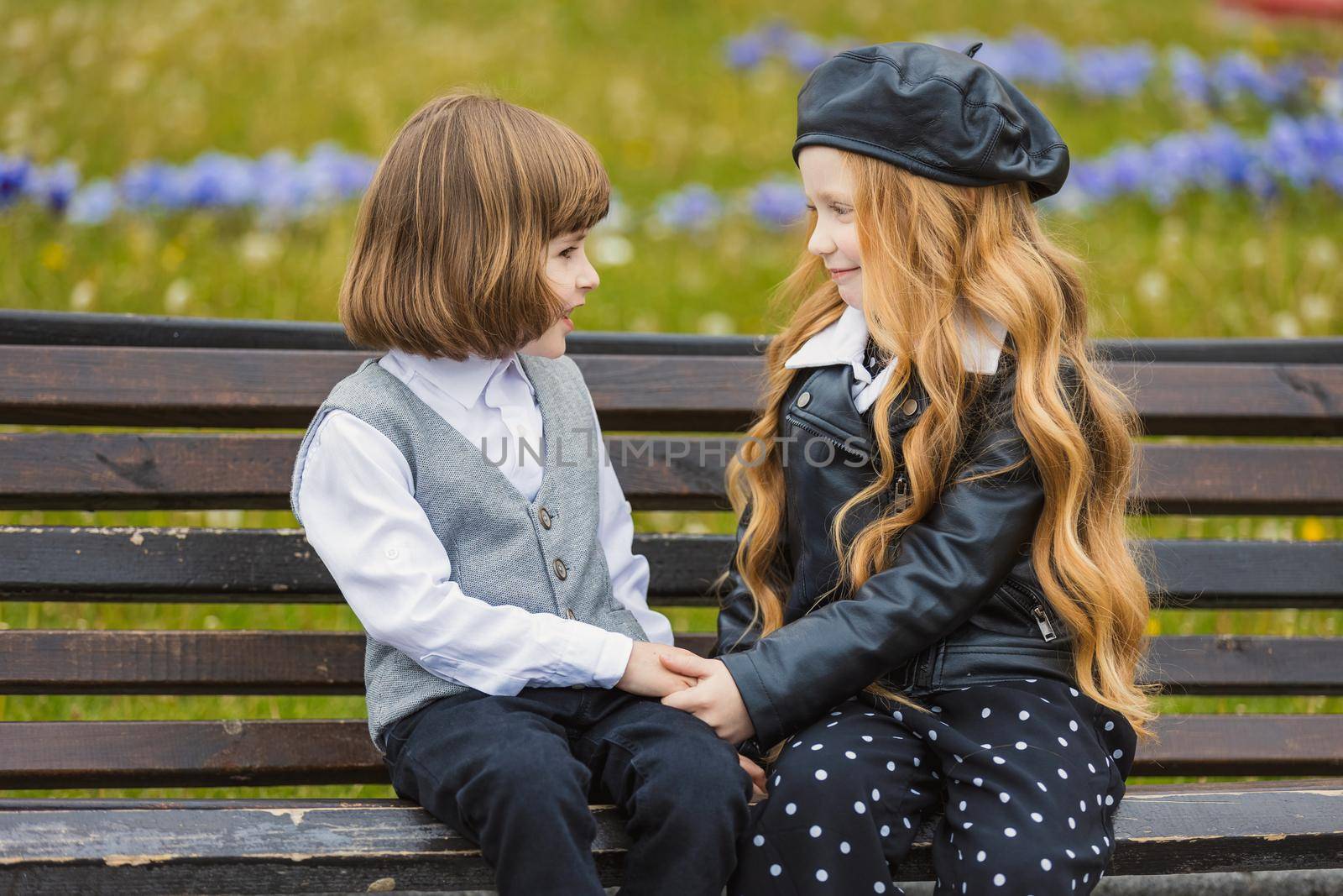 children sit on a bench and look at each other