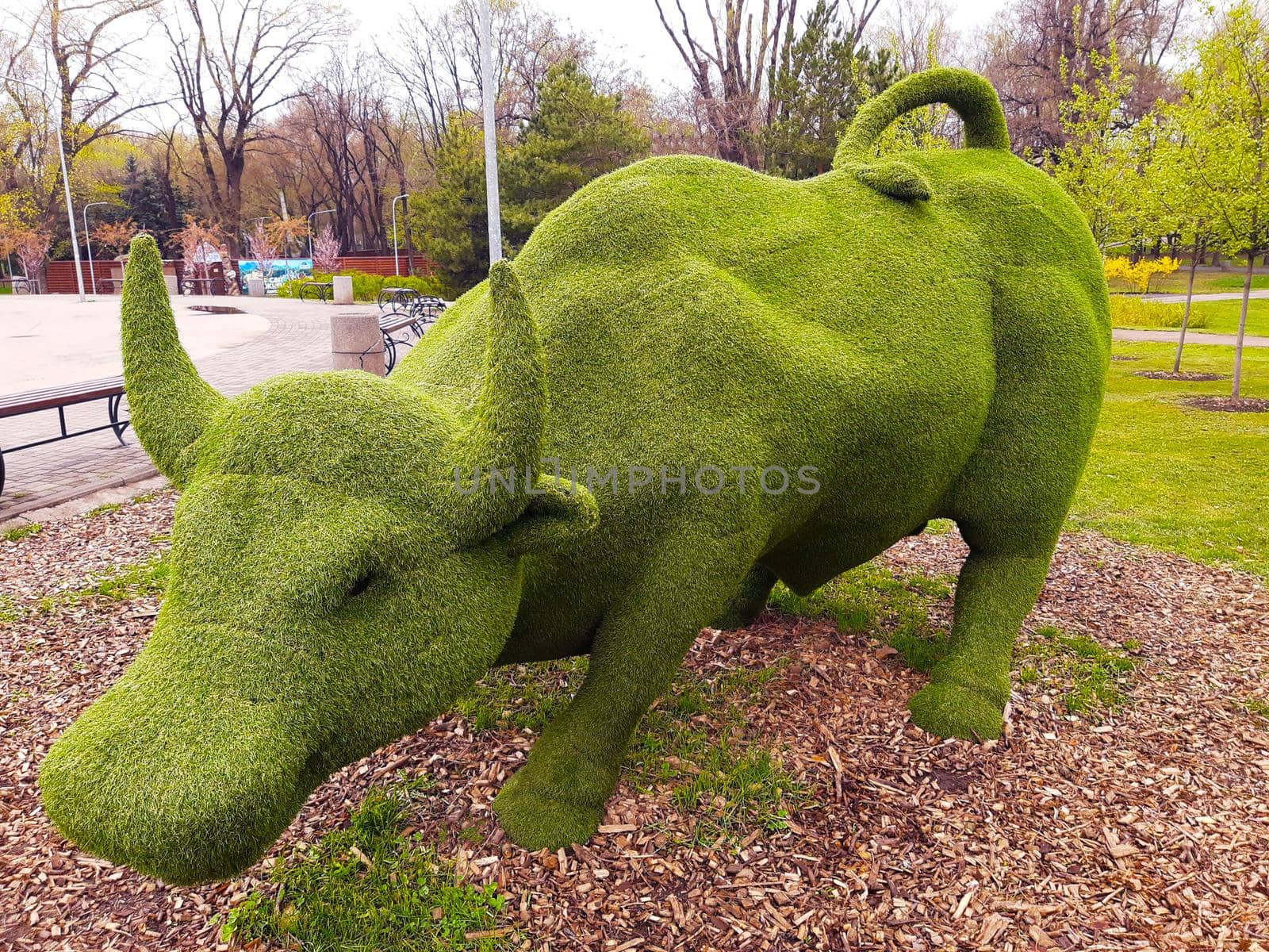 Decorative sculpture of a bull in a city park close-up.