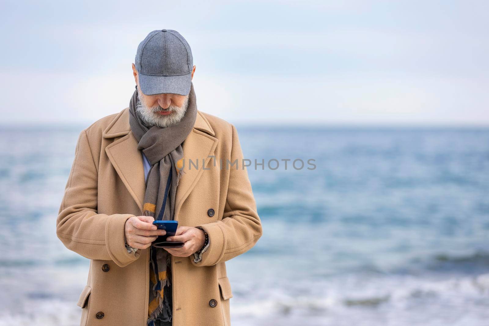 old man walking on the beach by zokov