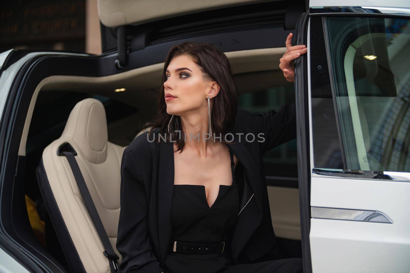 girl in the back passenger seat of a car getting ready to get out