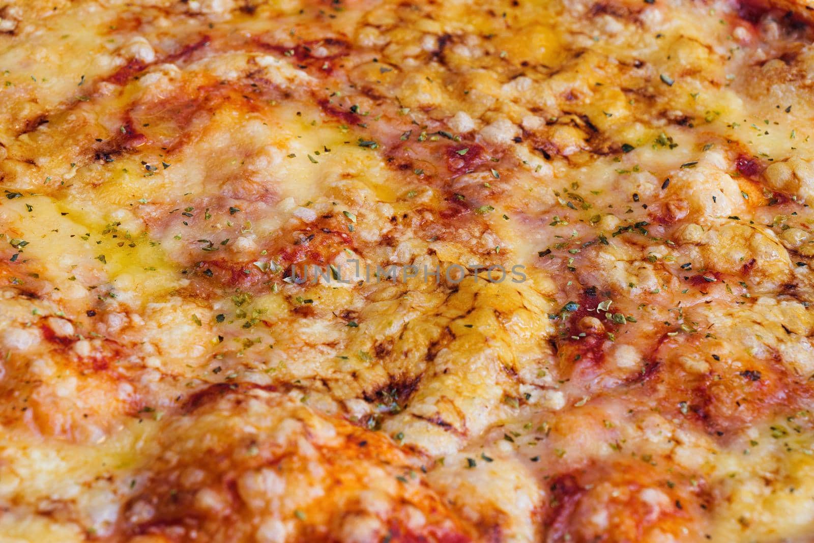 Close-up of pizza topped with cheese and oregano. Macro shot of delicious products. by apavlin