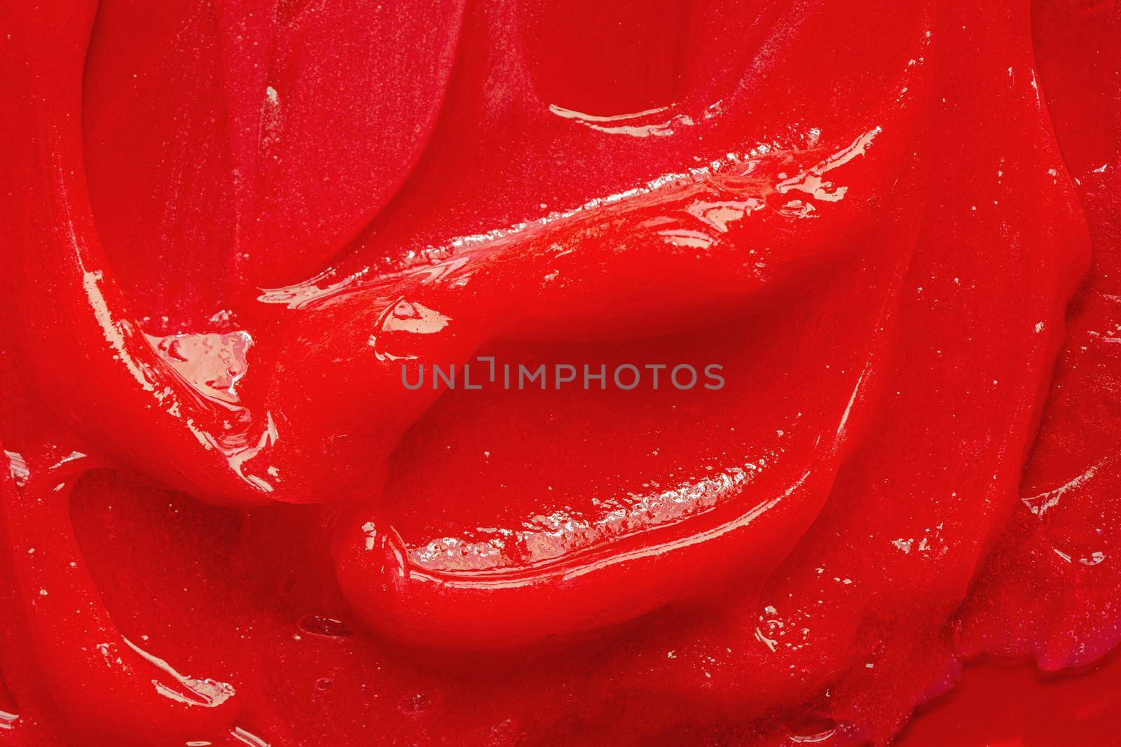 Red gel texture. Cosmetic clear liquid cream smudge. Skin care product sample closeup. Toothpaste or wax by photolime