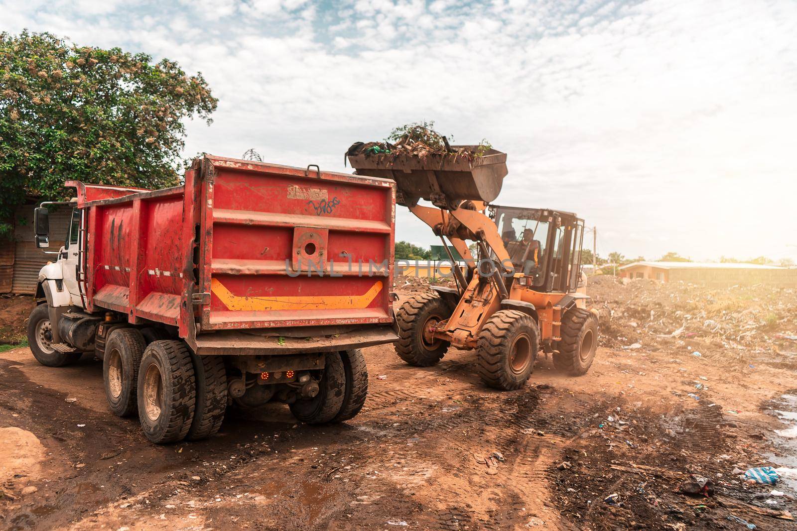 A mechanical shovel and a tractor collecting waste in a garbage dump in a city of Managua, Nicaragua. Concept of cleaning in communities of Central America, Latin America and Central America.