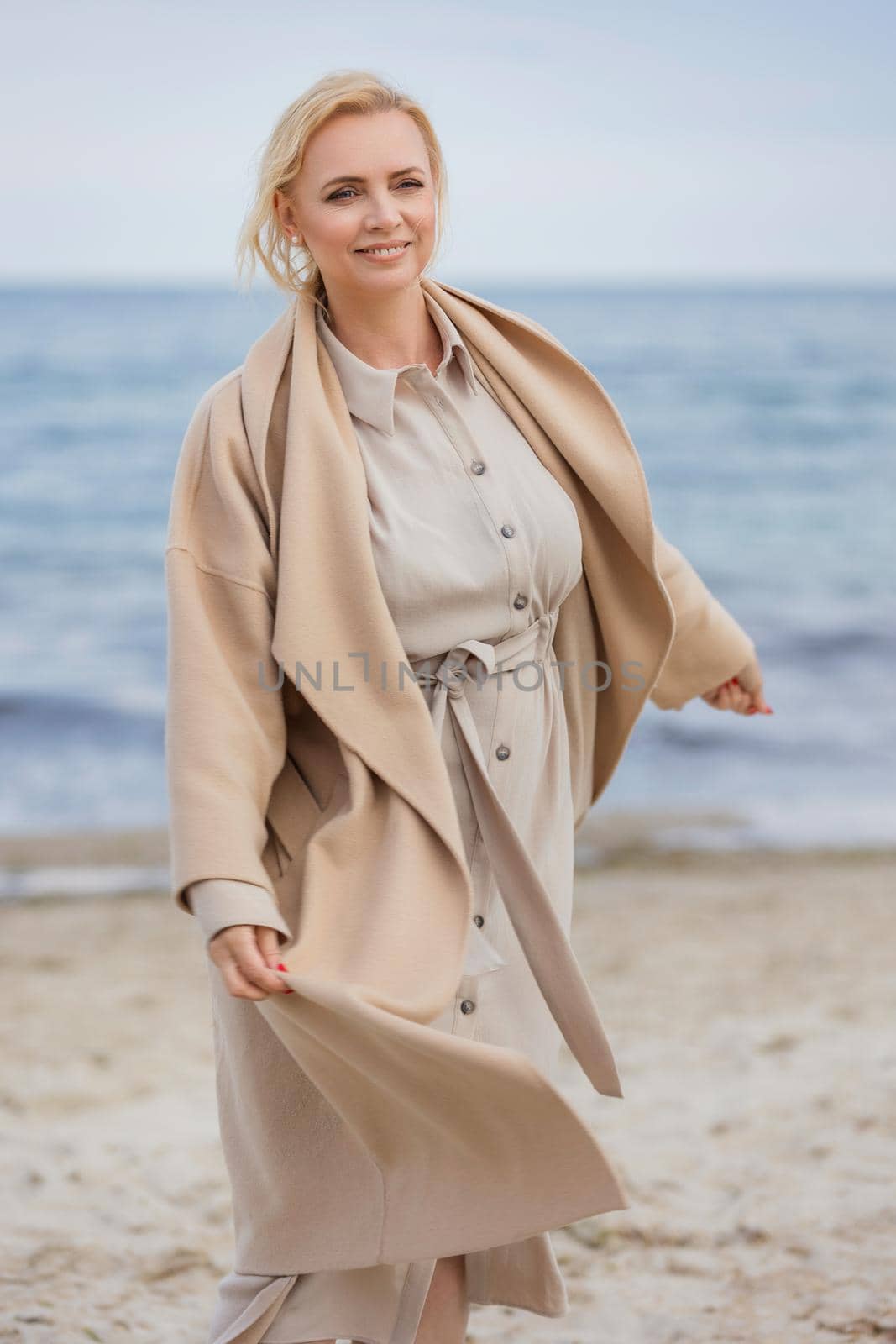 woman aged walking on the beach against the background of the sea