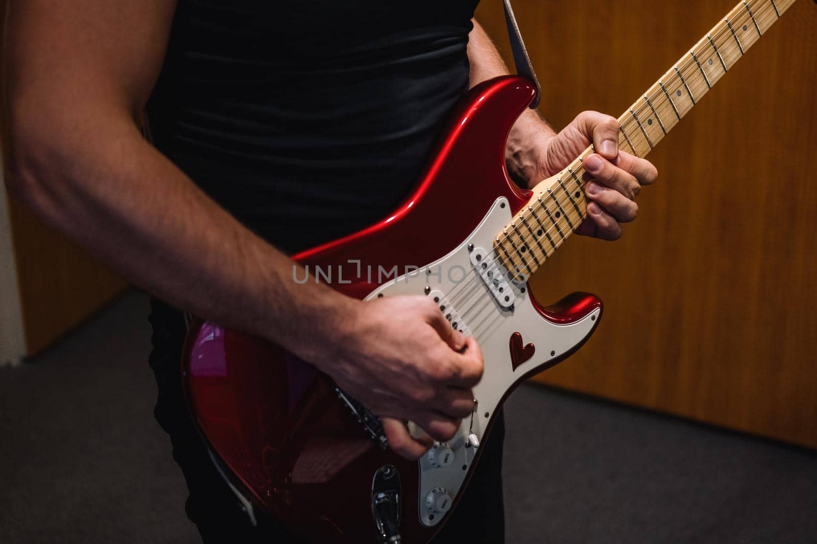 Repetition of rock music band. Cropped image of electric guitar player. Rehearsal base