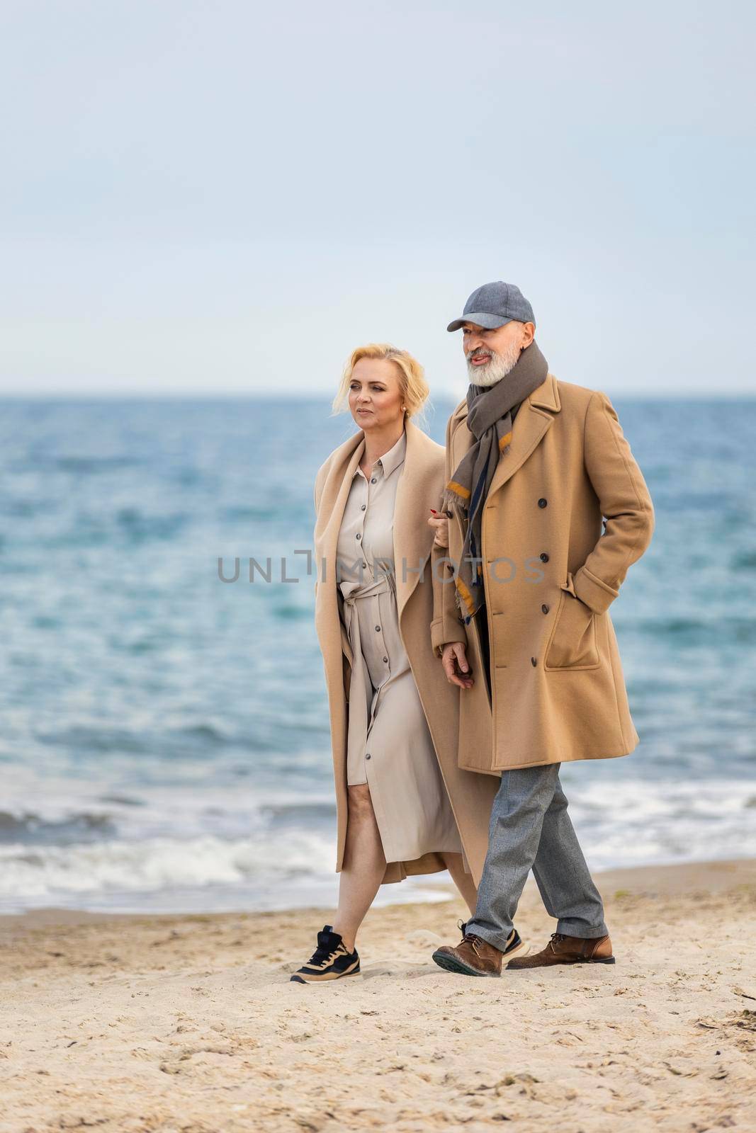 aged couple walking along the seashore