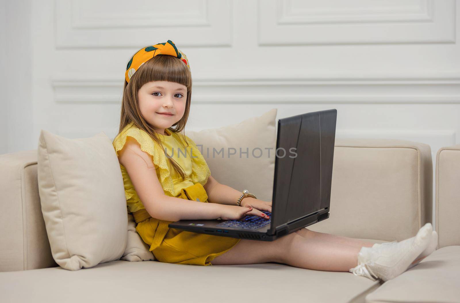 girl sitting on the couch with a laptop